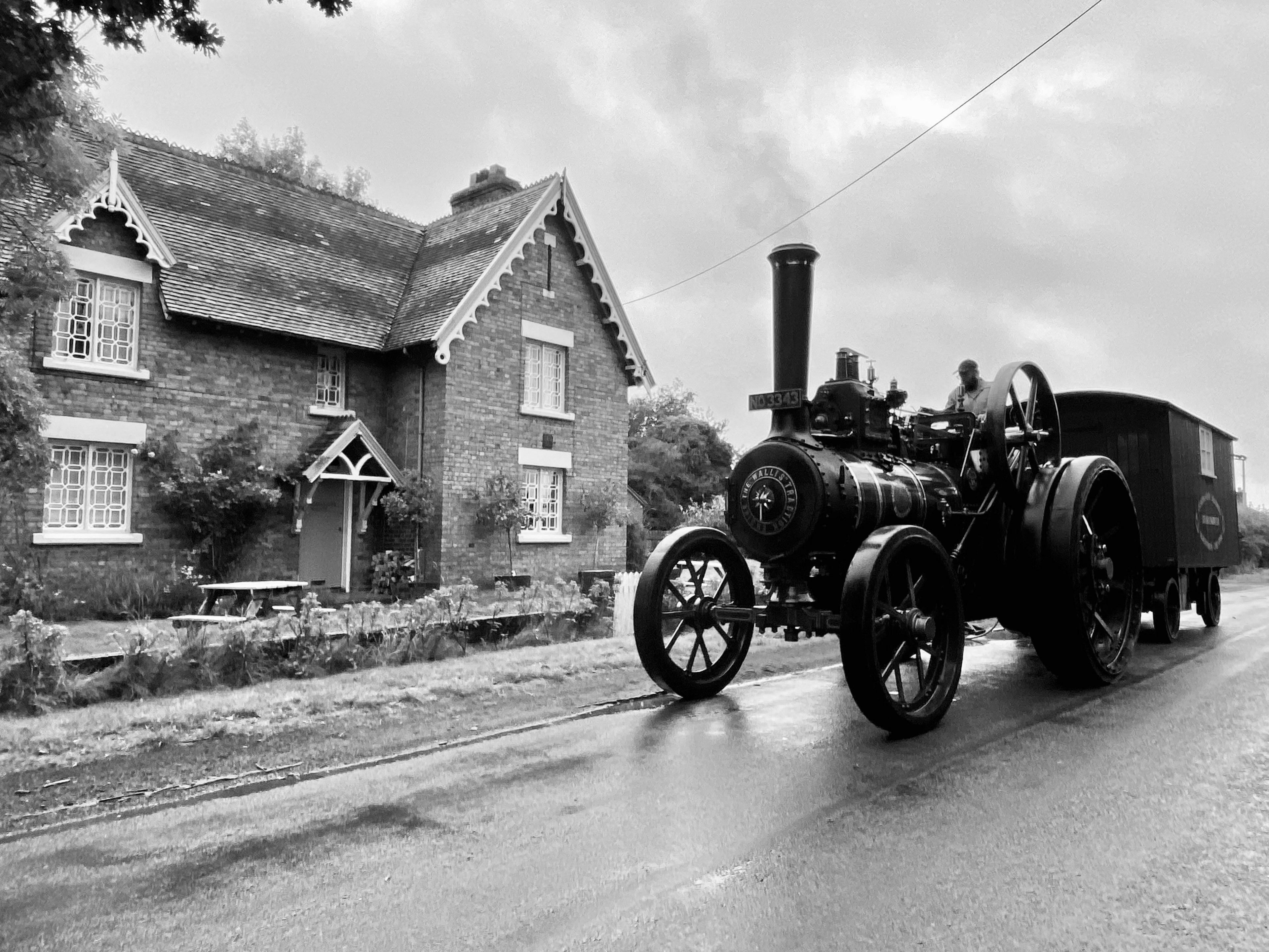 A traction engine passes a house