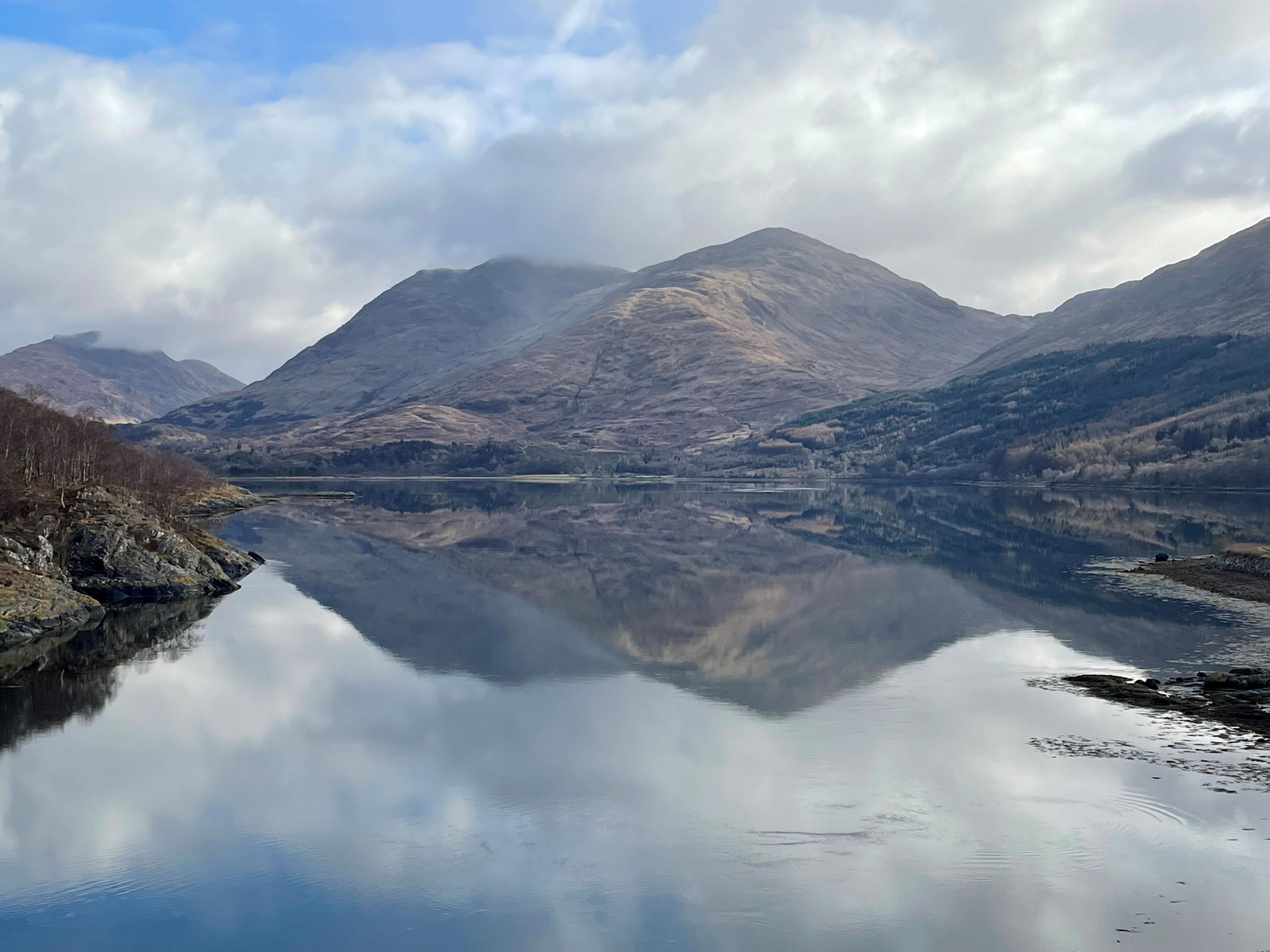 A mountain range reflected on a loch.