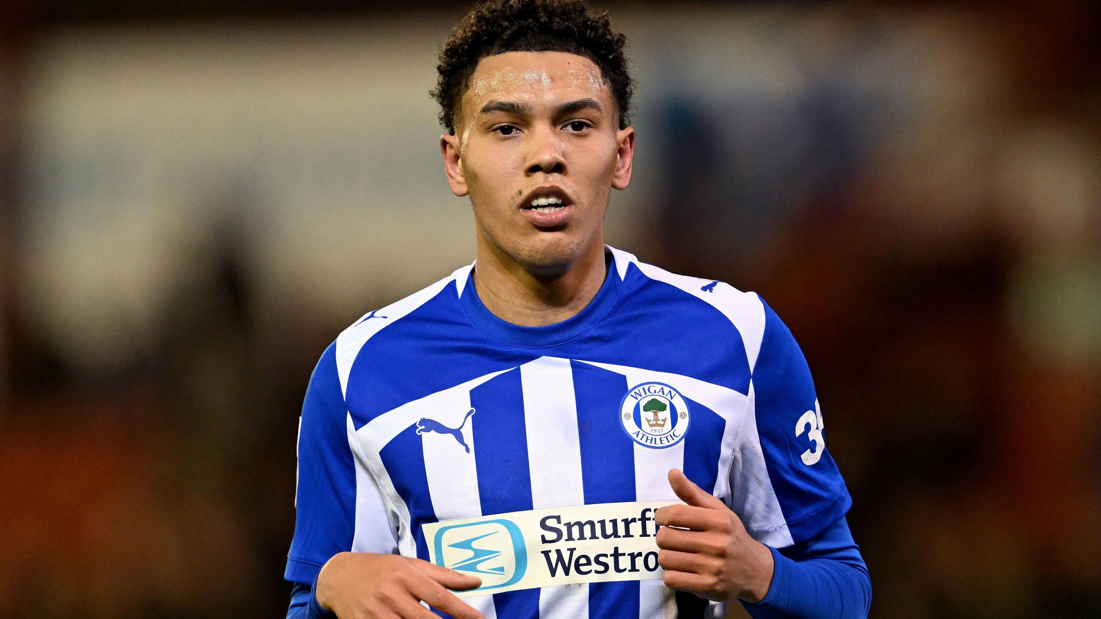 Llyton Chapman in blue and white striped Wigan shirt