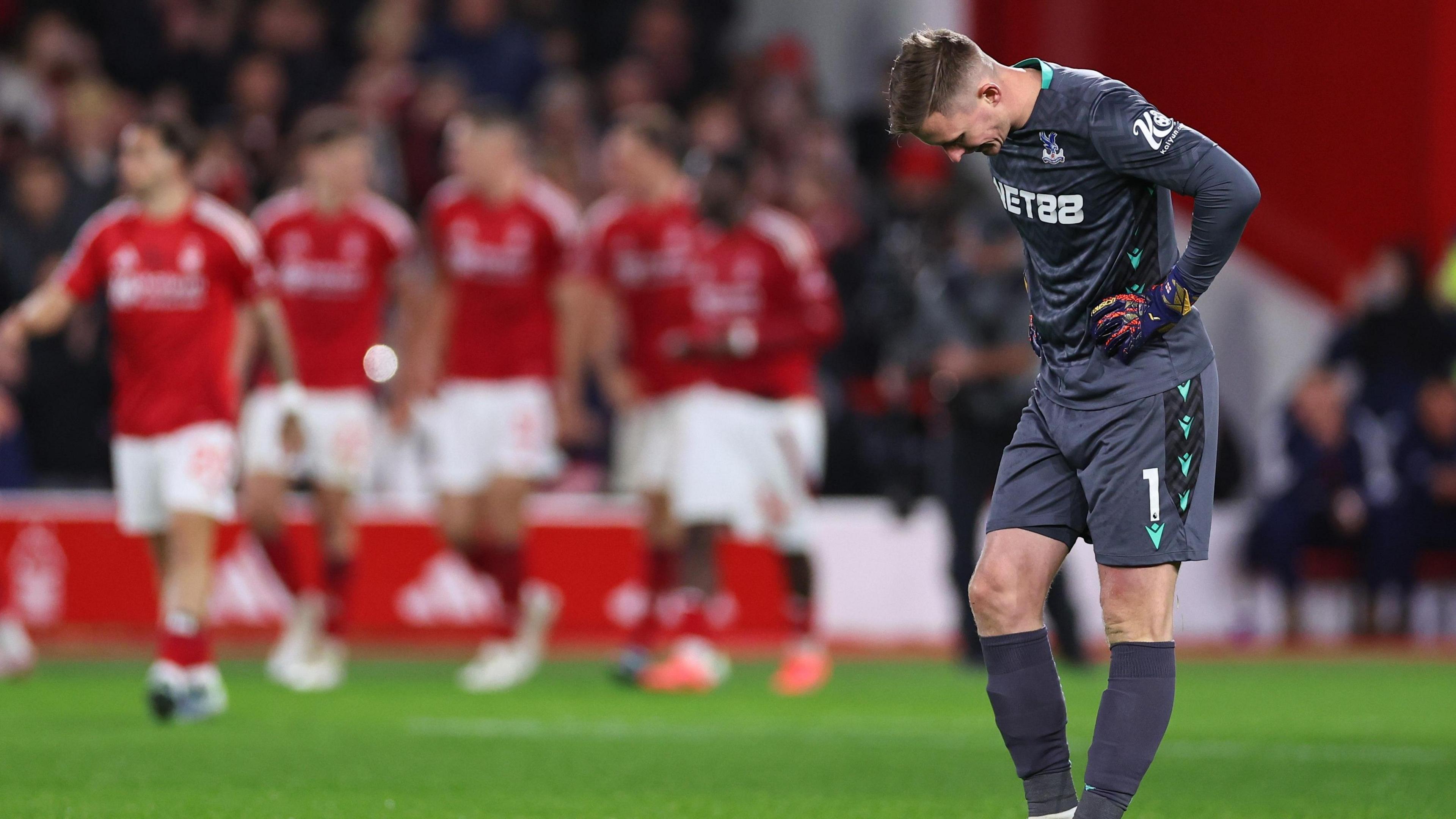 Dean Henderson looks dejected as Nottingham Forest celebrate Chris Wood's goal. 