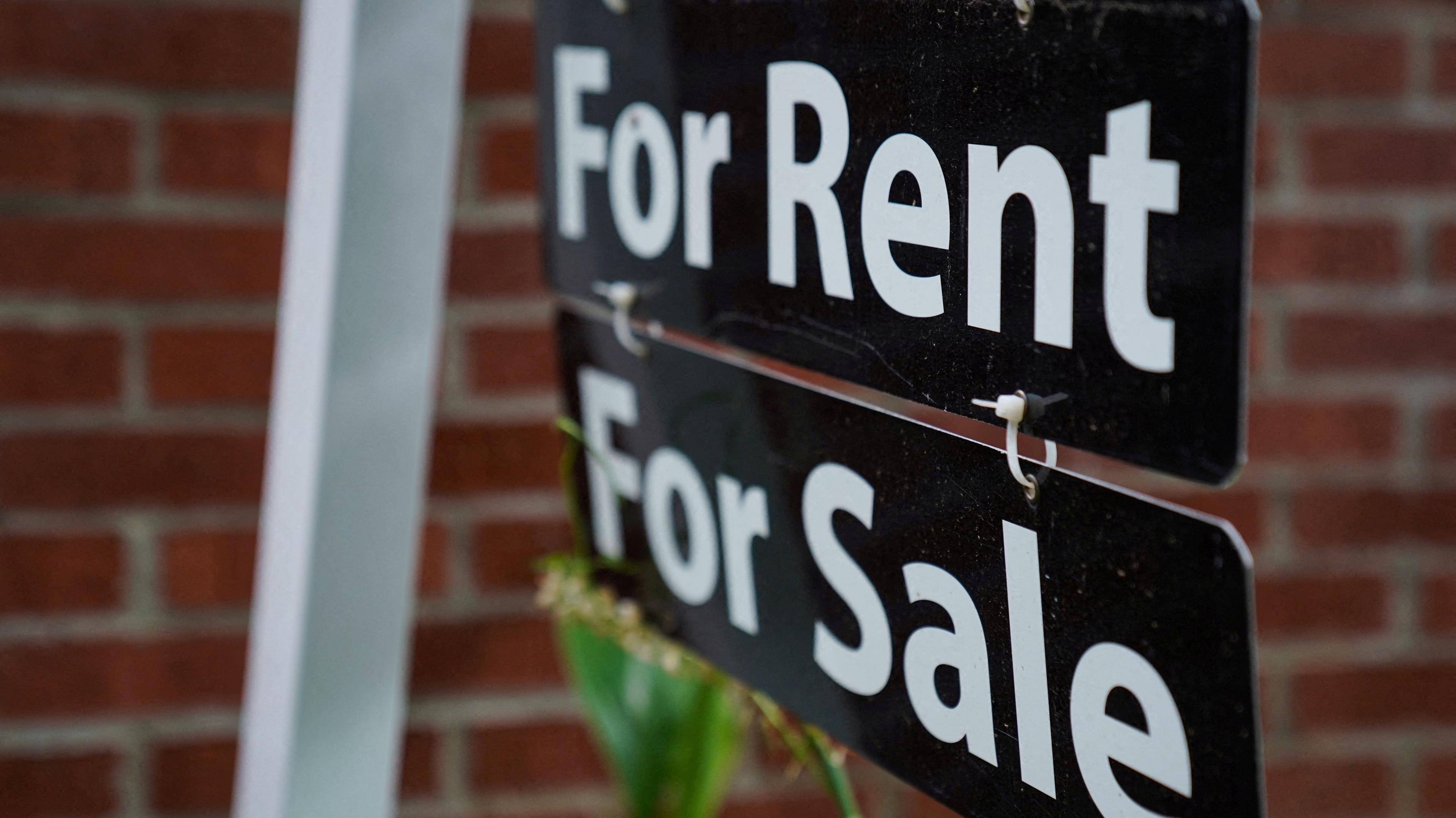 A sign that says "For Rent" and "For Sale" in white lettering on a black background.