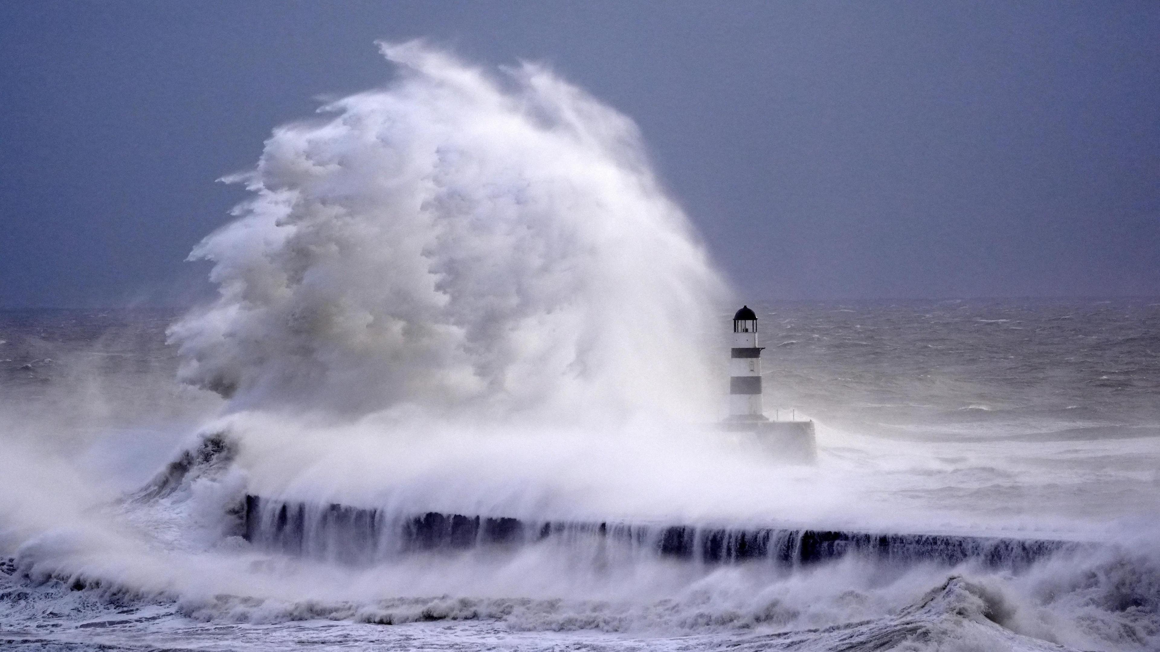 Waves crash against the lighthouse in Seaham Harbour, County Durham