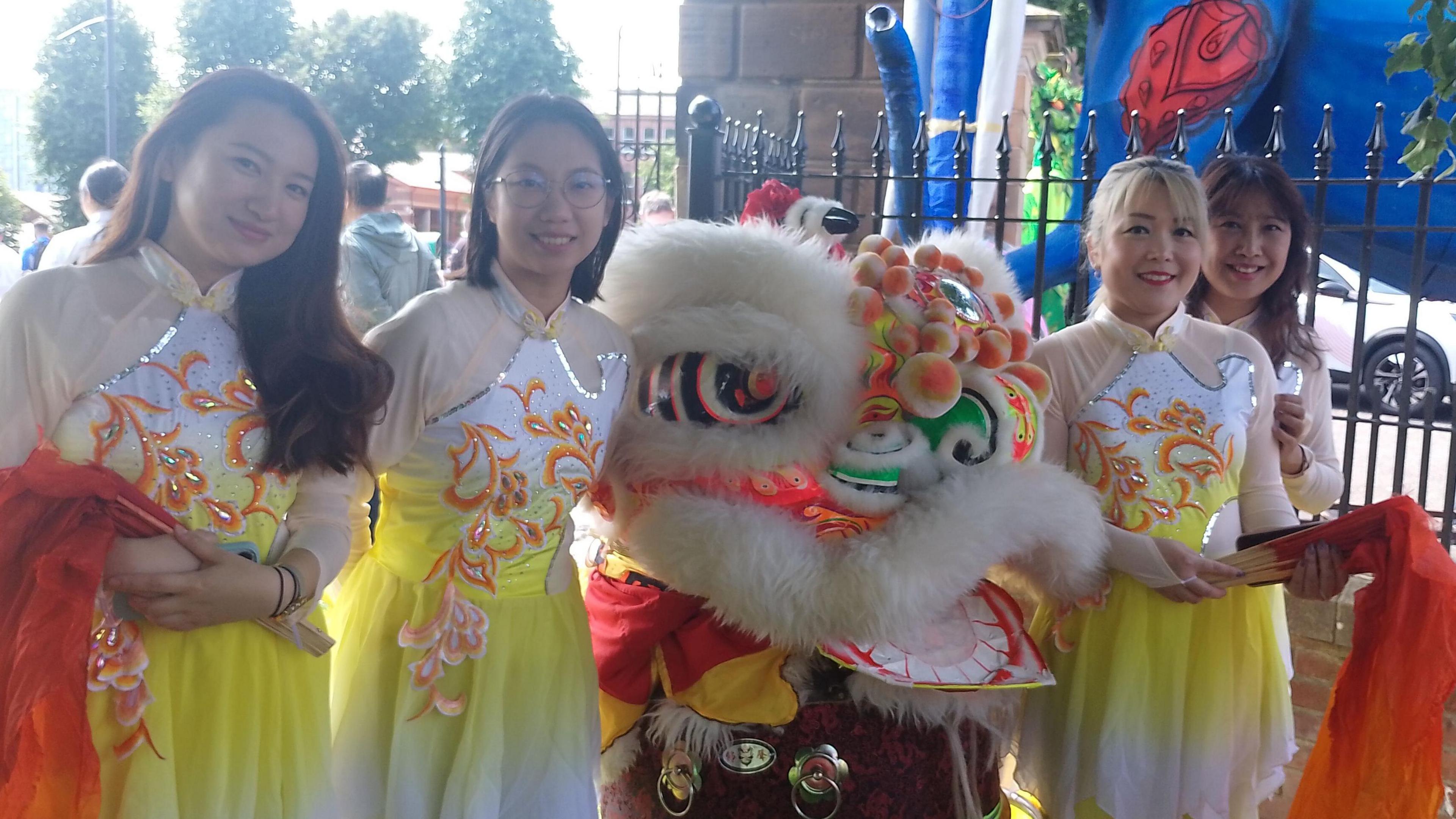 Four people dressed in ceremonial clothing stood, smiling at the camera.
