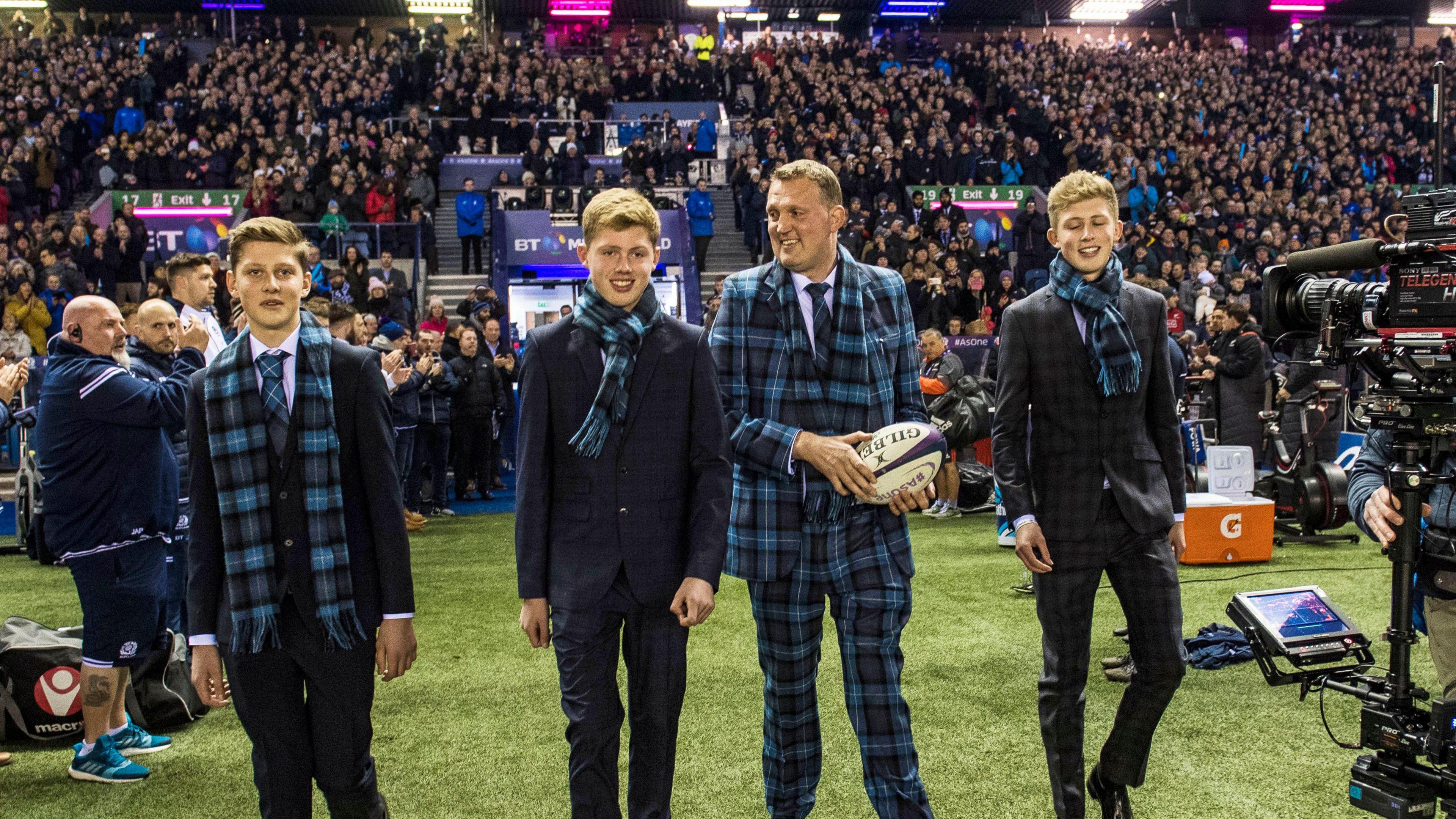 Doddie Weir presents the match ball at Murrayfield, flanked by his sons