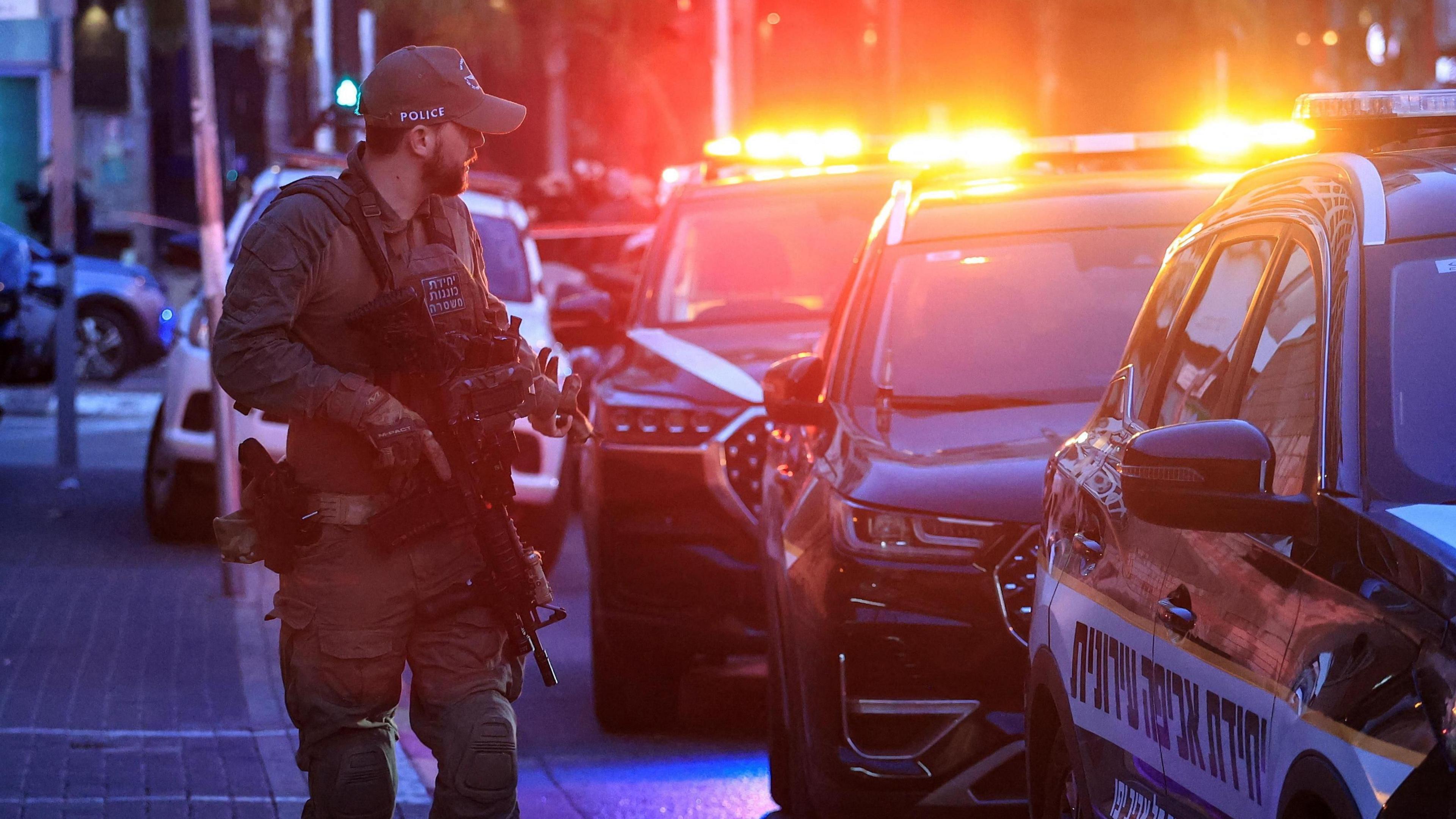 An Israeli police officer walks at the scene of a suspected attack in Tel Aviv,