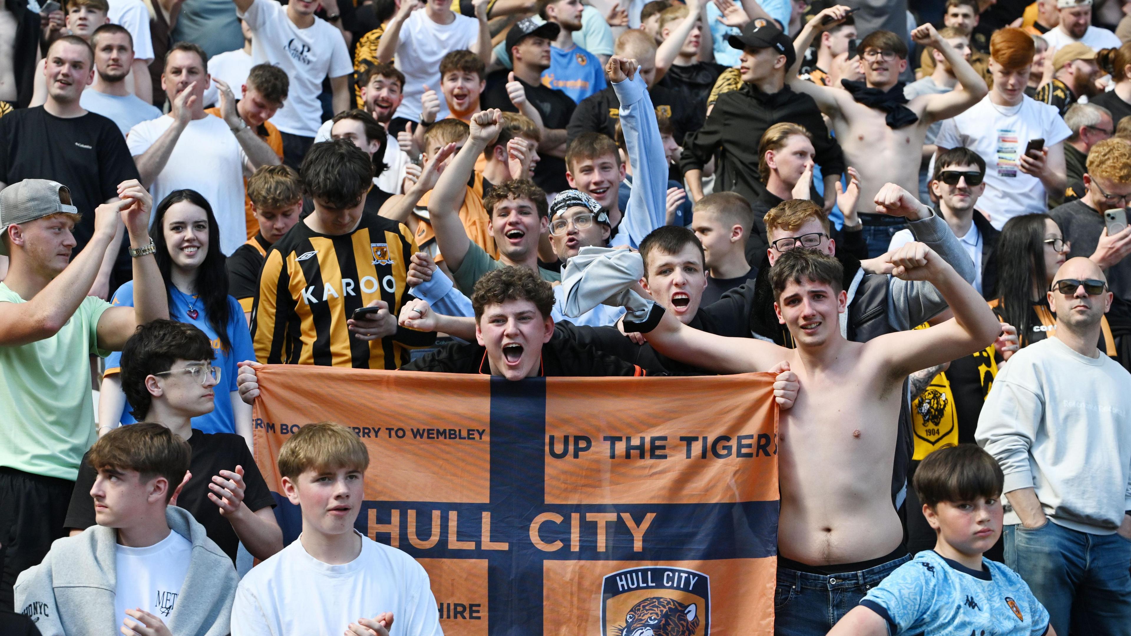 One Hull City fan holds up a flag to celebrate reaching the Championship play-offs.