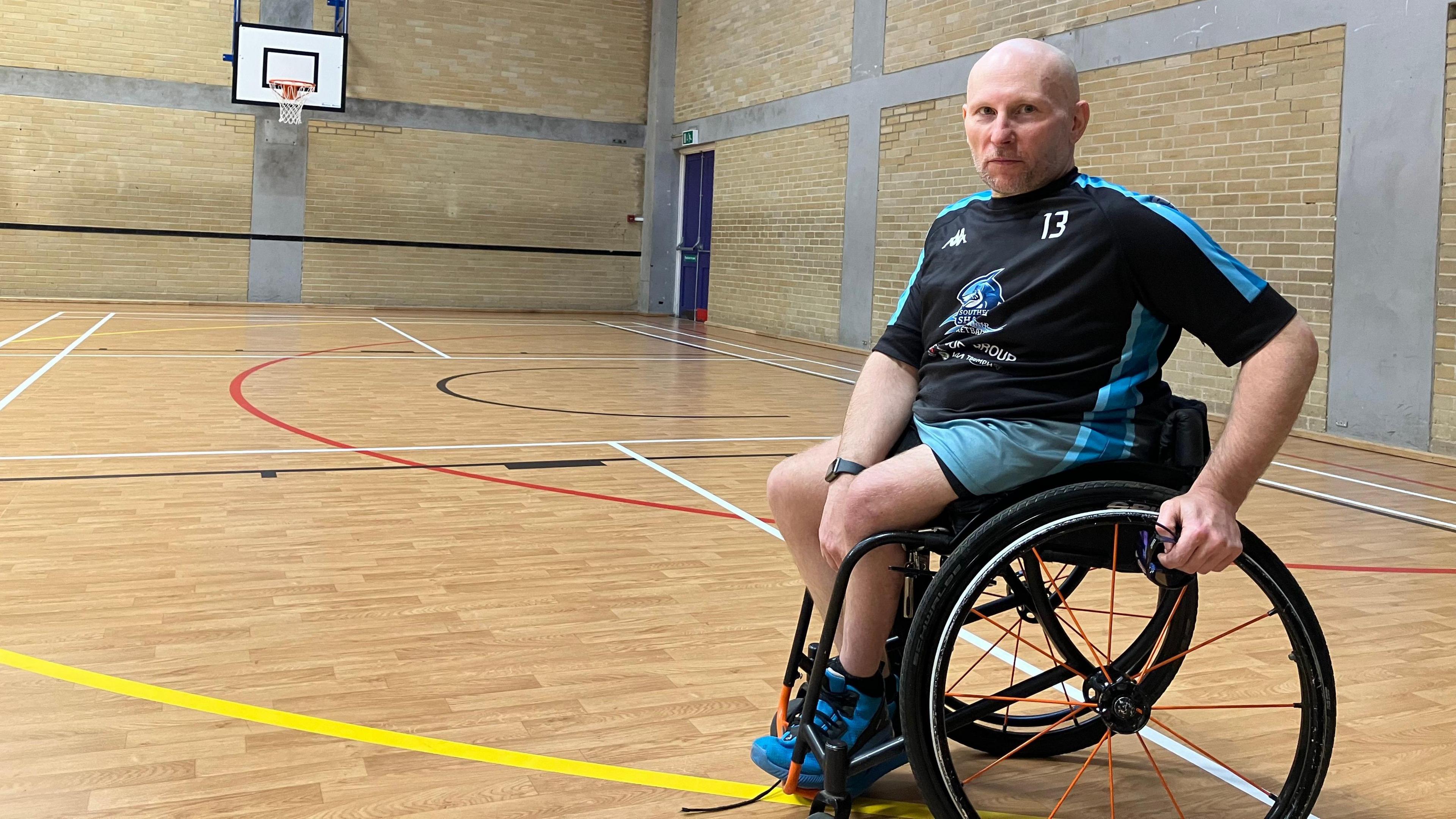 Pete Bull, a wheelchair user who is sat on an indoor basketball court