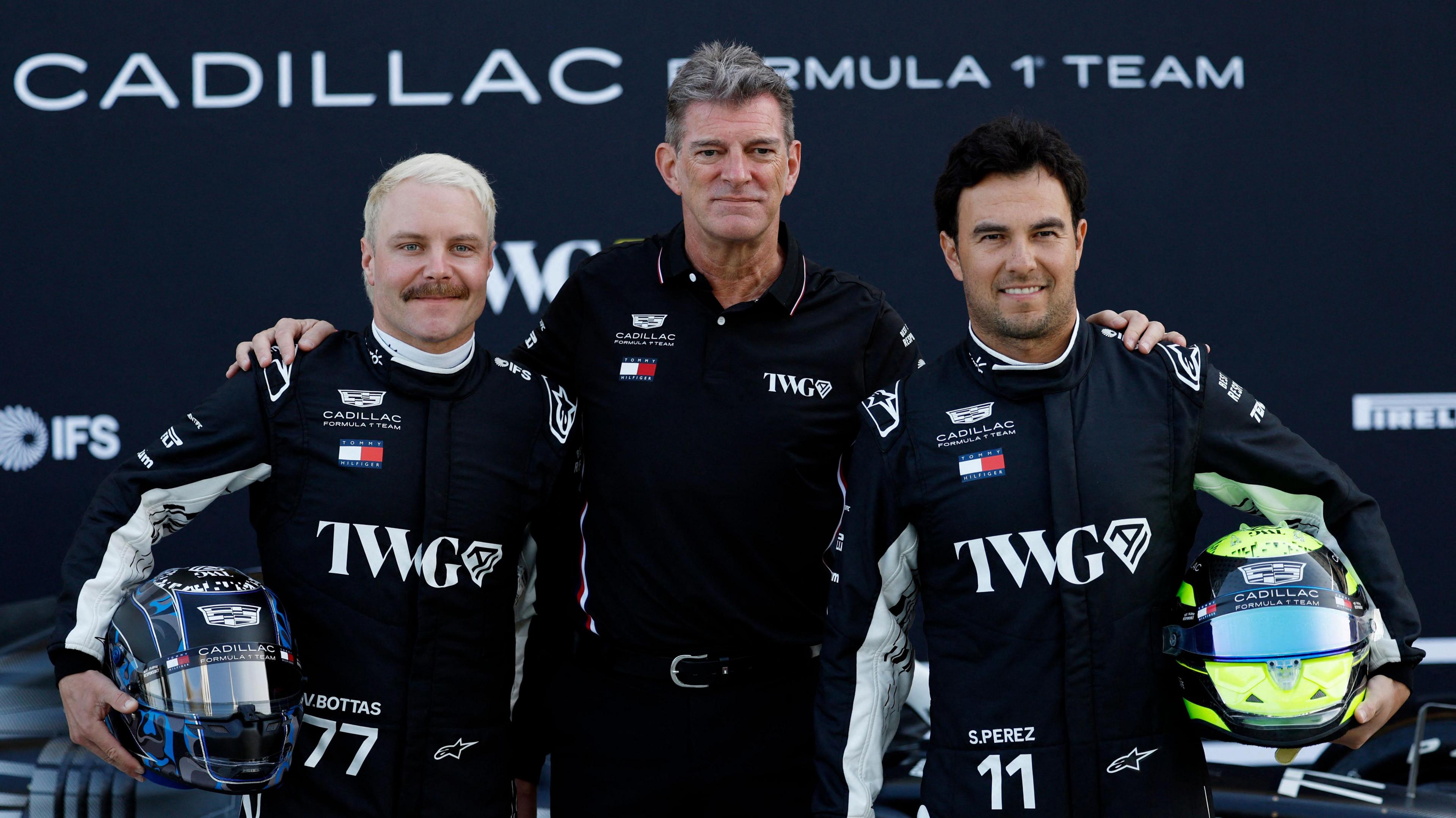 Cadillac's F1 drivers Valtteri Bottas and Sergio Perez pose for a picture during Bahrain testing with team principal Graeme Lowdon stood between them