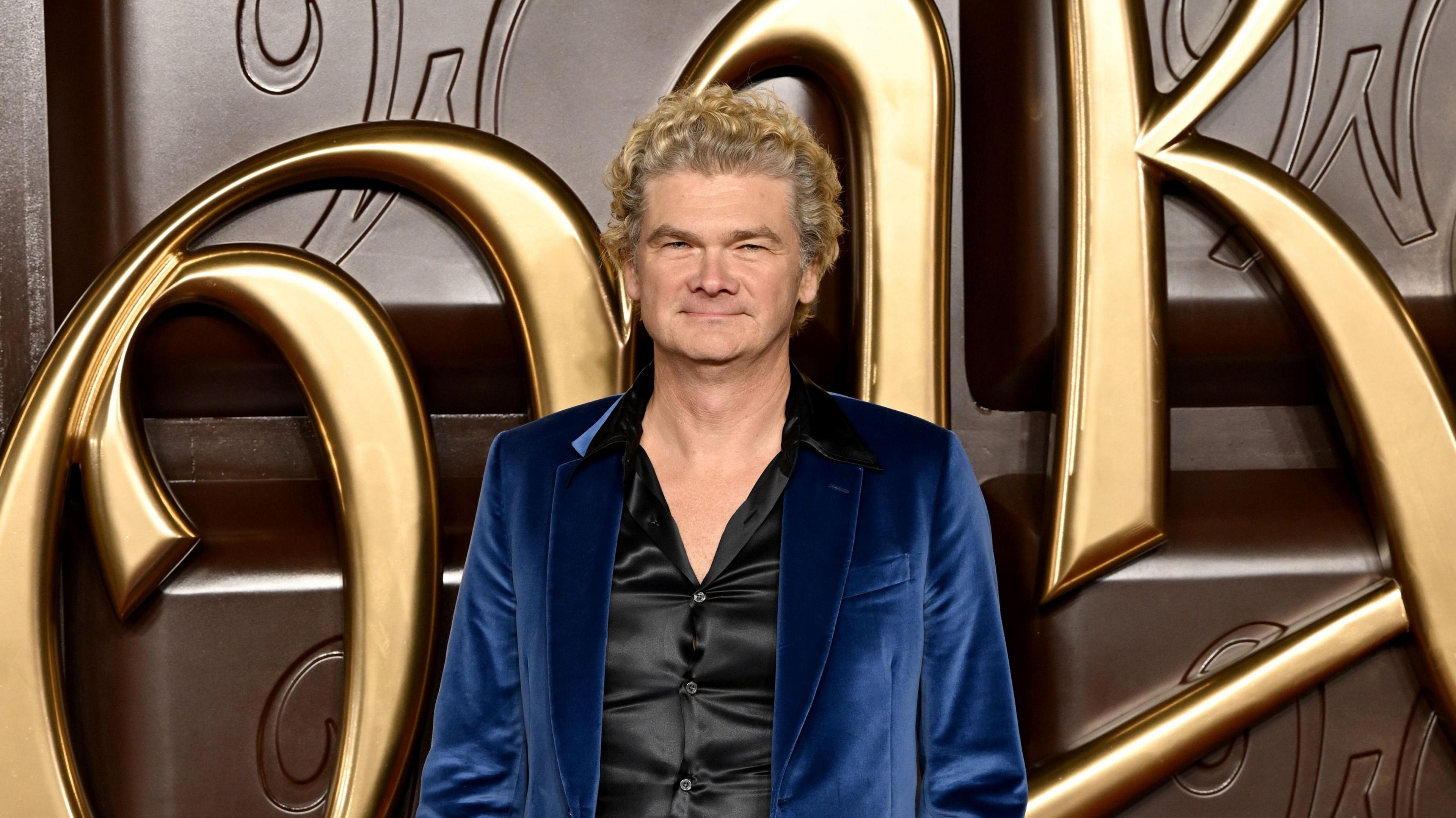 simon farnaby smiling at a red carpet event for the film wonka