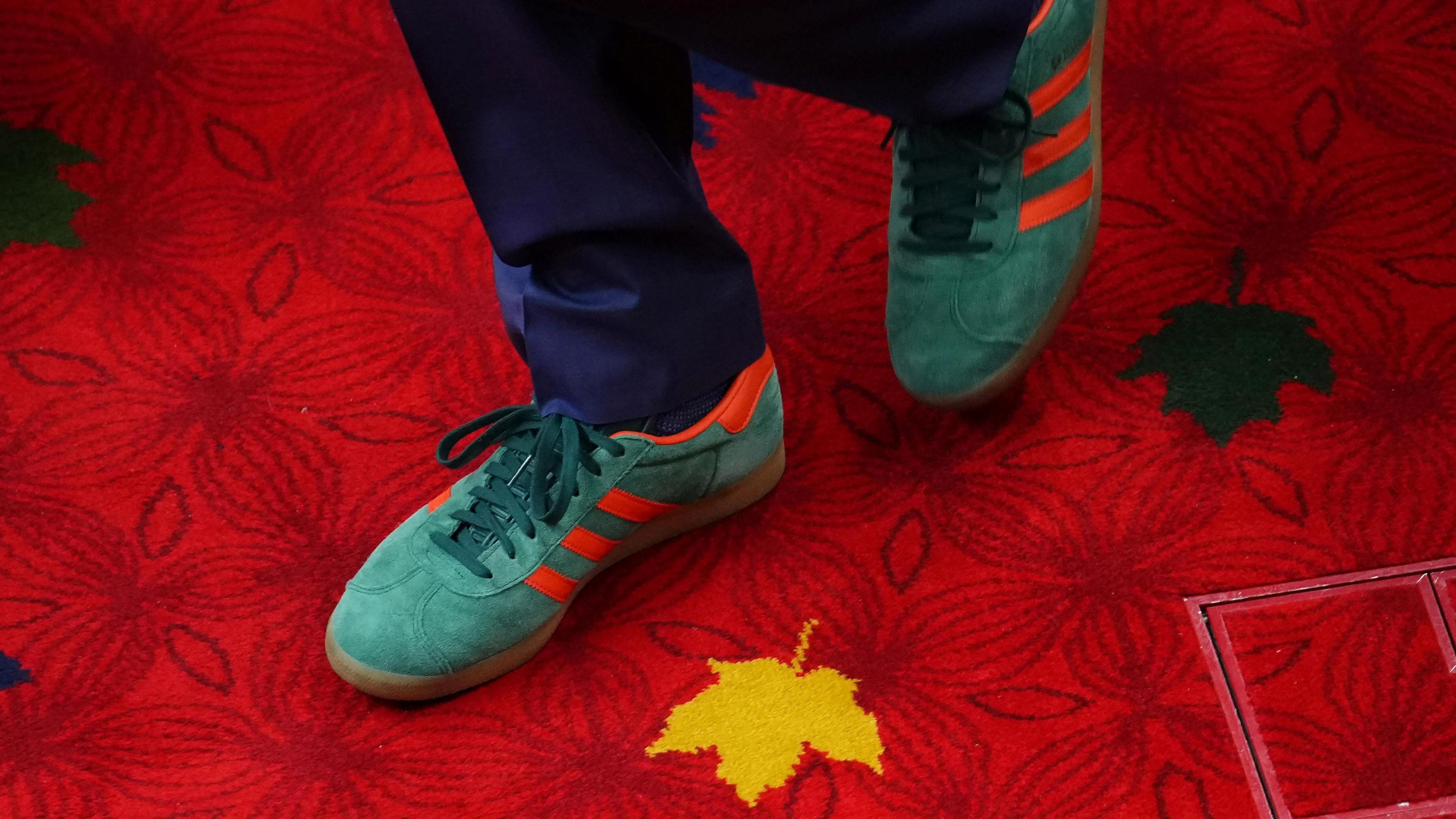 Justin Trudeau's red-striped green trainers, on a bright red carpet