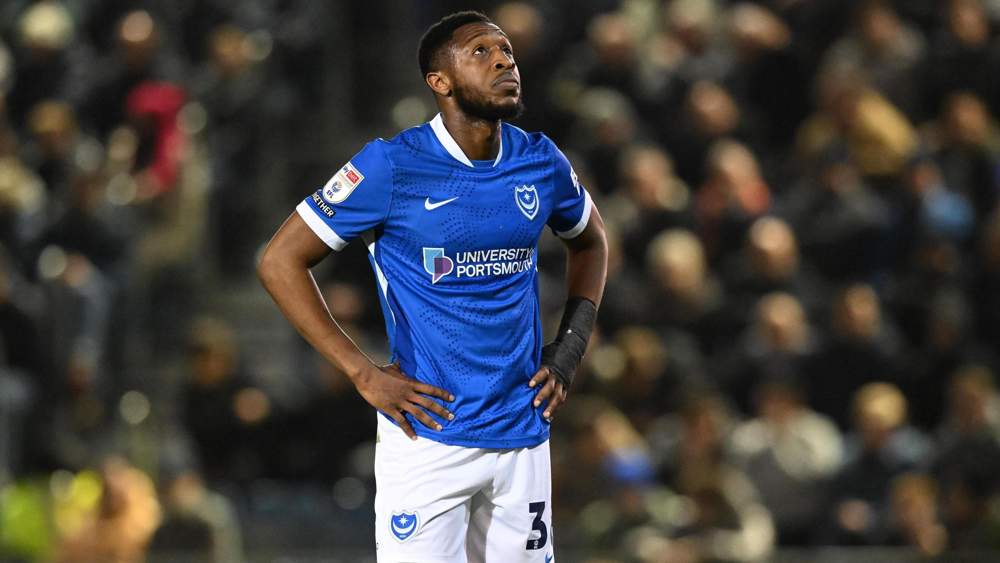 Ebou Adams looks to the sky with his hands on his hips