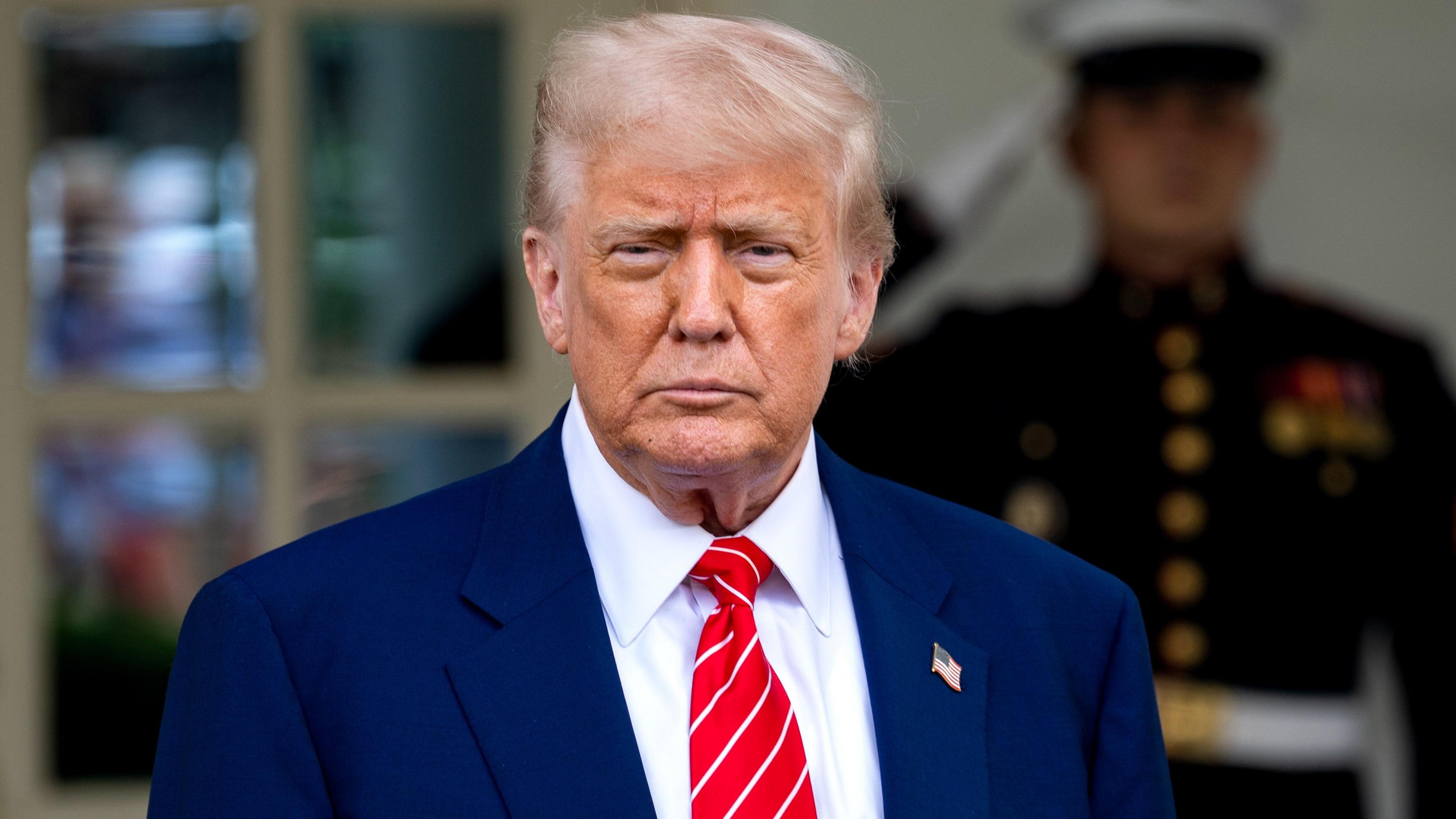 President Donald Trump in a dark suit and red tie 