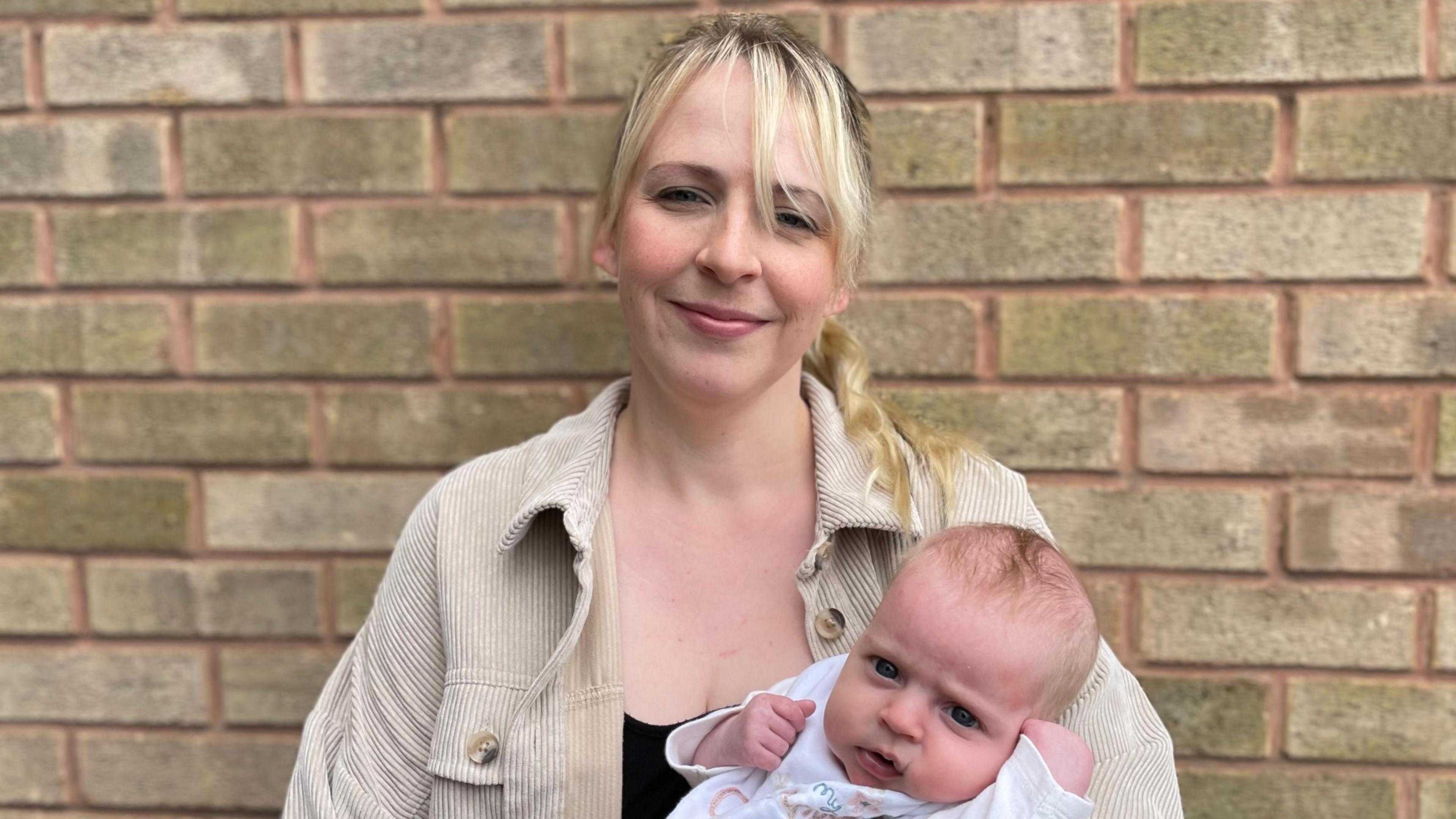 Portrait of Claire Arthur holding a baby