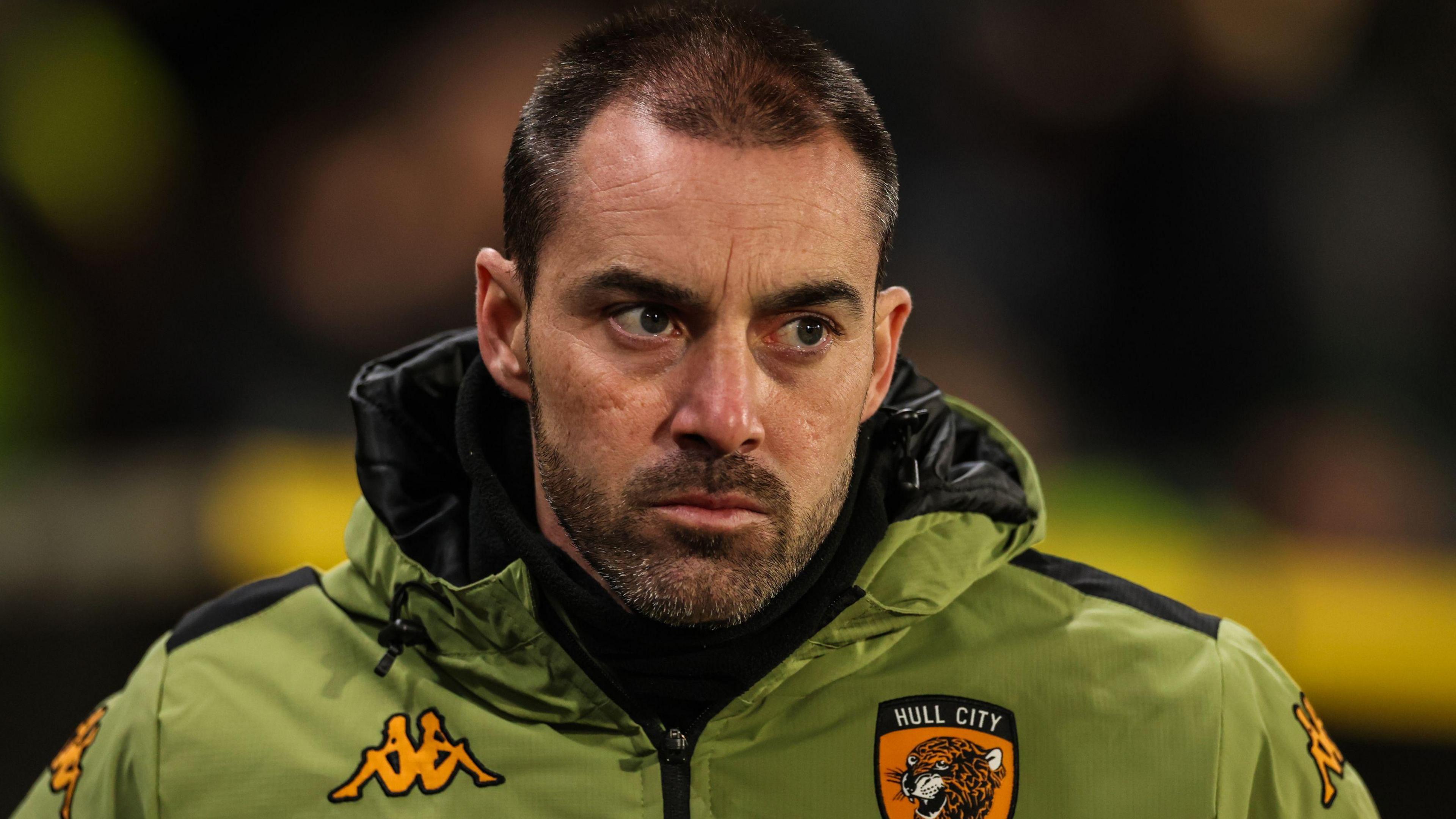 Hull City boss Ruben Selles pictured on the touchline in a club jacket