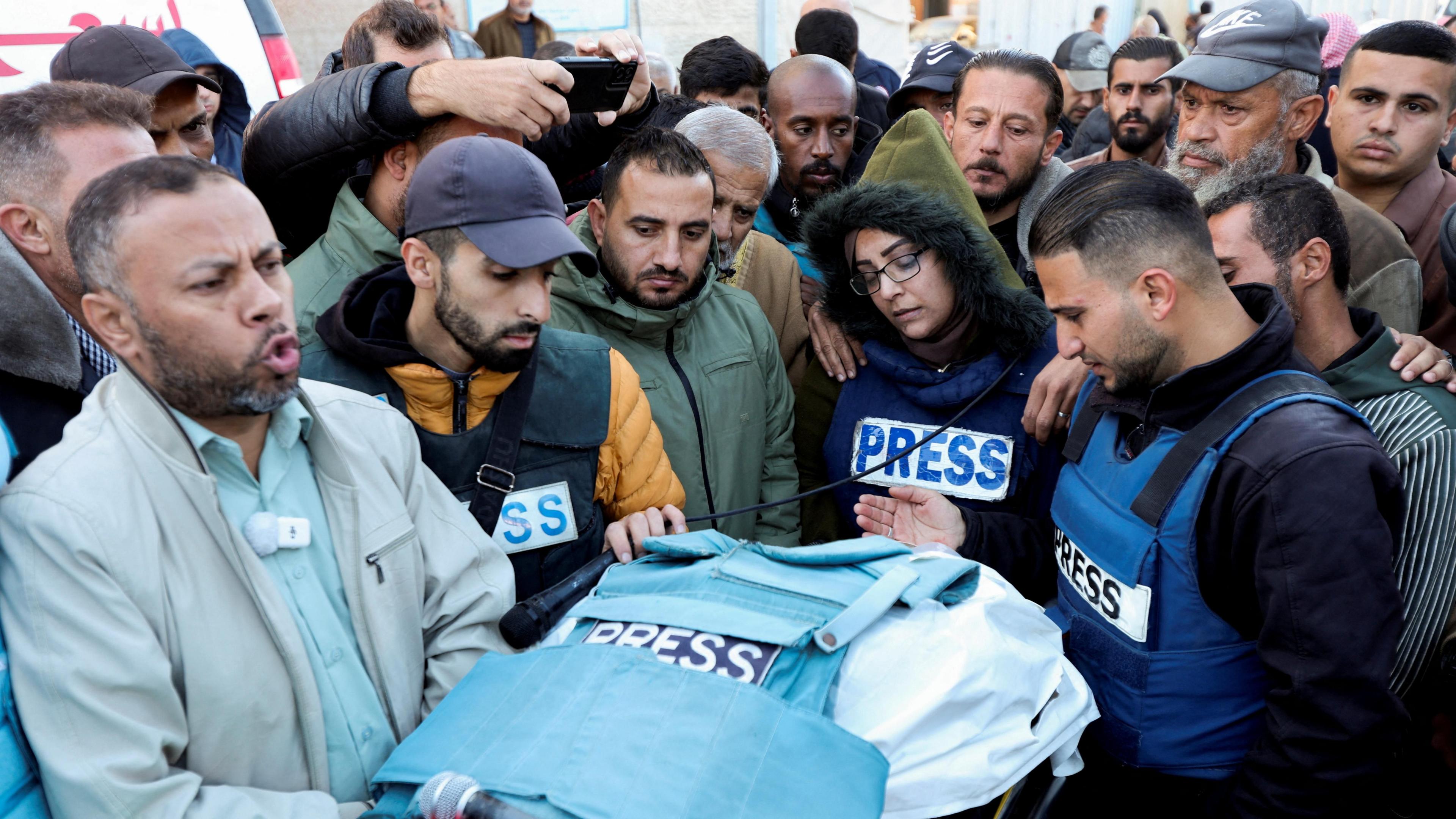 Journalists and other Palestinian mourn next the body of Al Jazeera cameraman Ahmad Baker al-Louh, after he was killed in an Israeli air strike in Nuseirat refugee camp, central Gaza (16 December 2024)