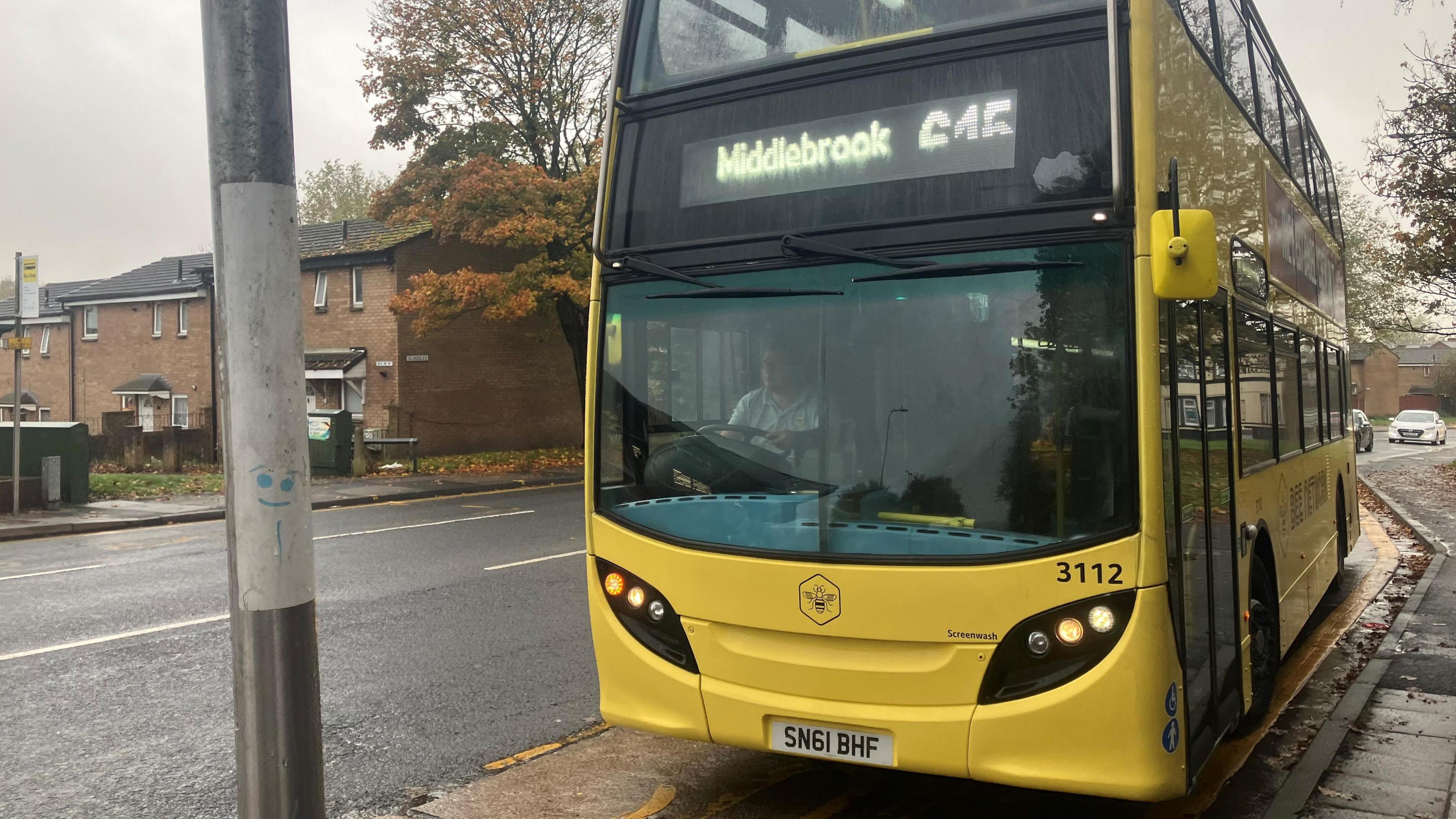 A yellow Bee Network bus bearing the 615 name number to Middlebrook seen parked in a bus lay-by on an overcast day. 