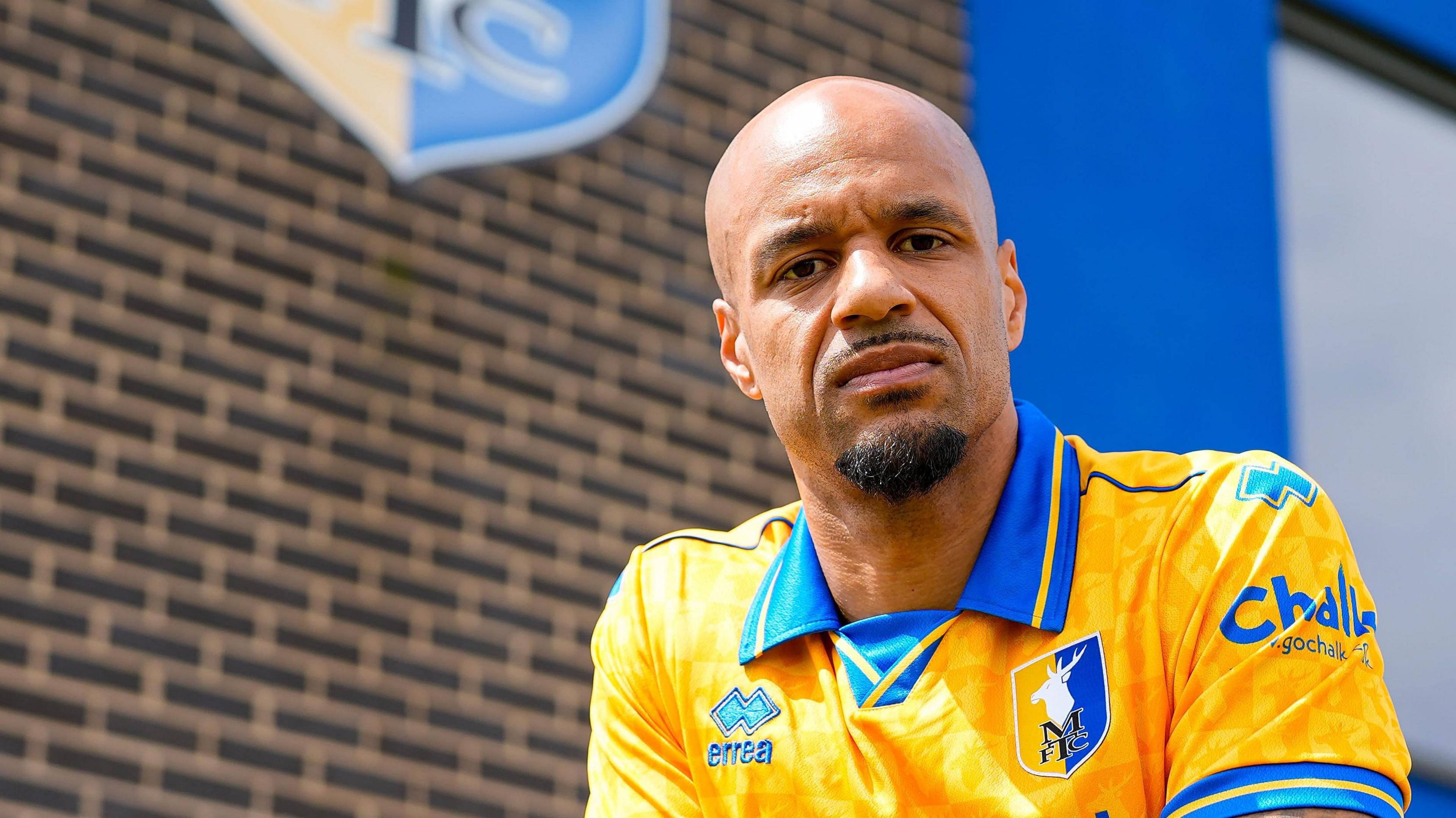David McGoldrick wearing a yellow and blue Mansfield Town shirt outside the Stags' training base