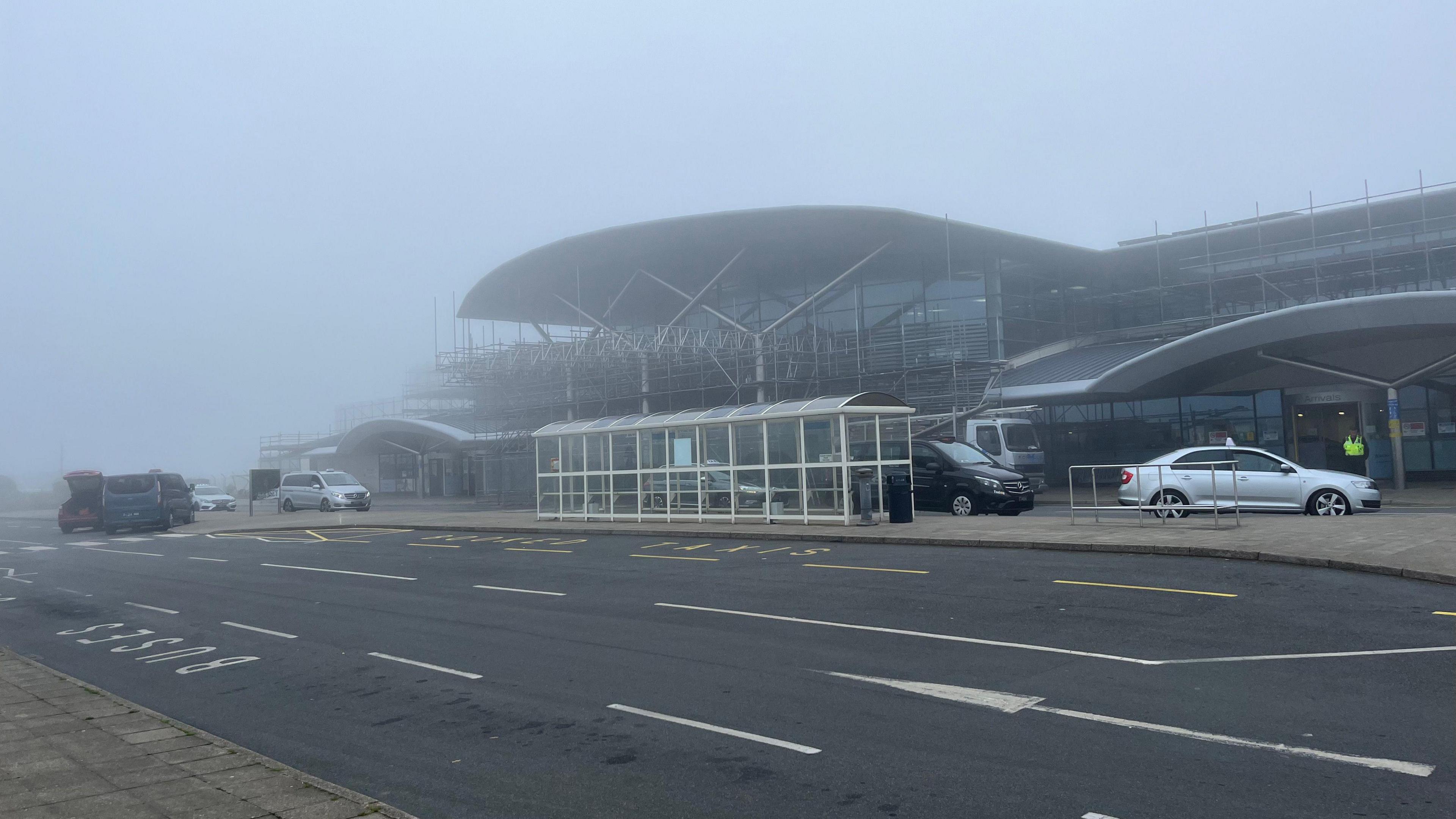 Photo of taxis waiting outside a very foggy Guernsey Airport