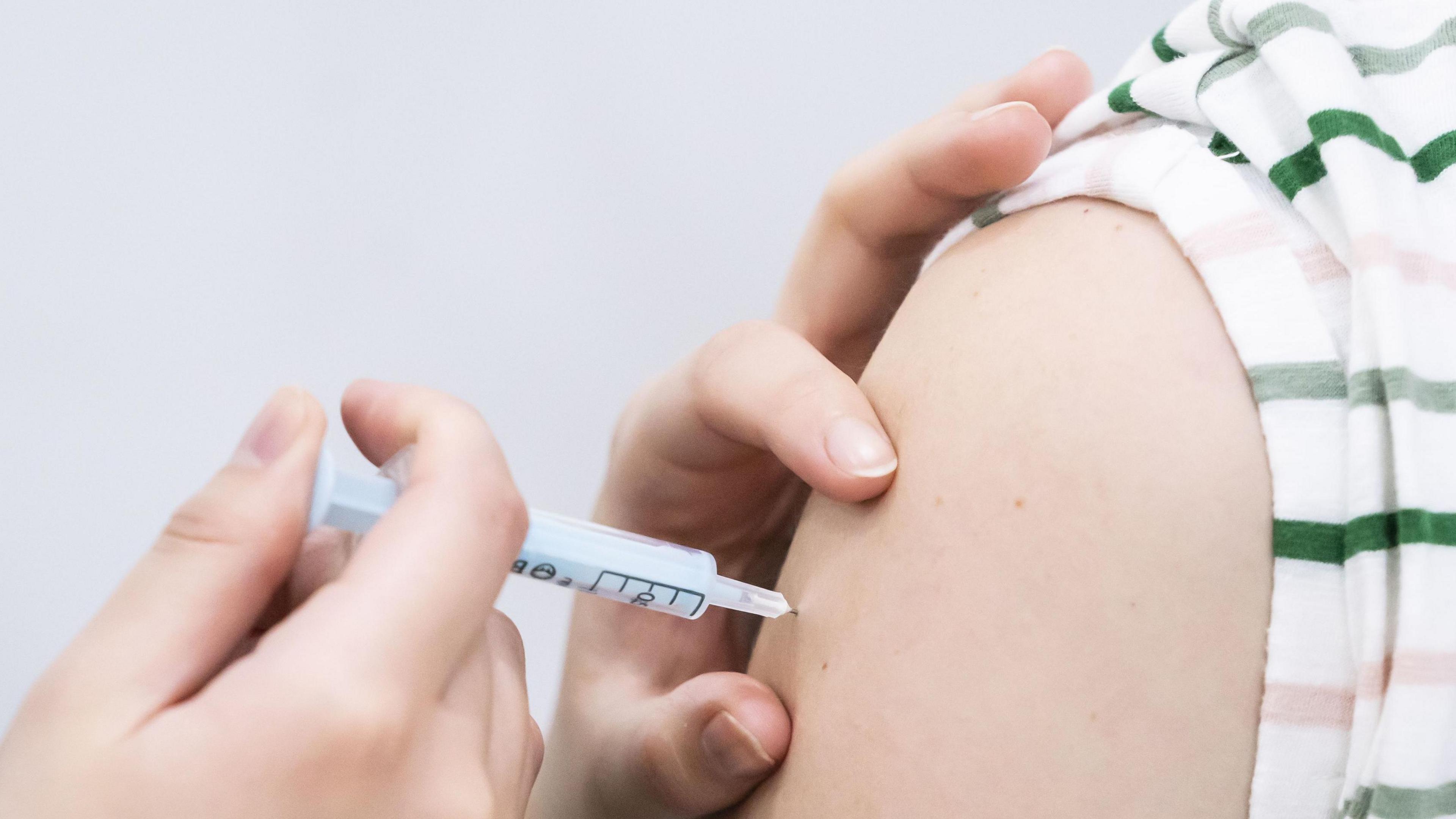 A picture of a vaccination being given to a patient