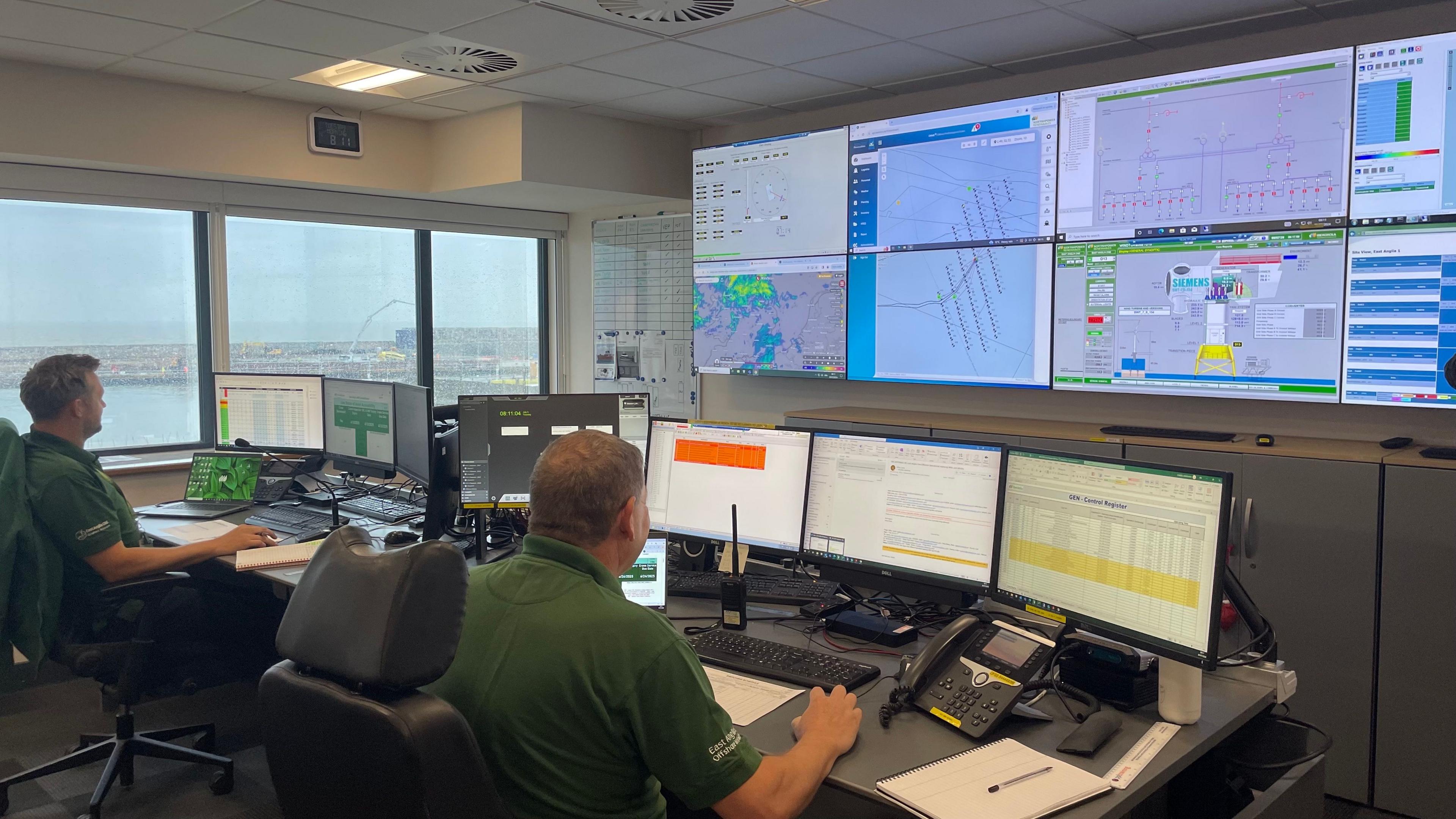 Two operators sit in front of a bank of screens, displaying data about the East Anglia One wind farm