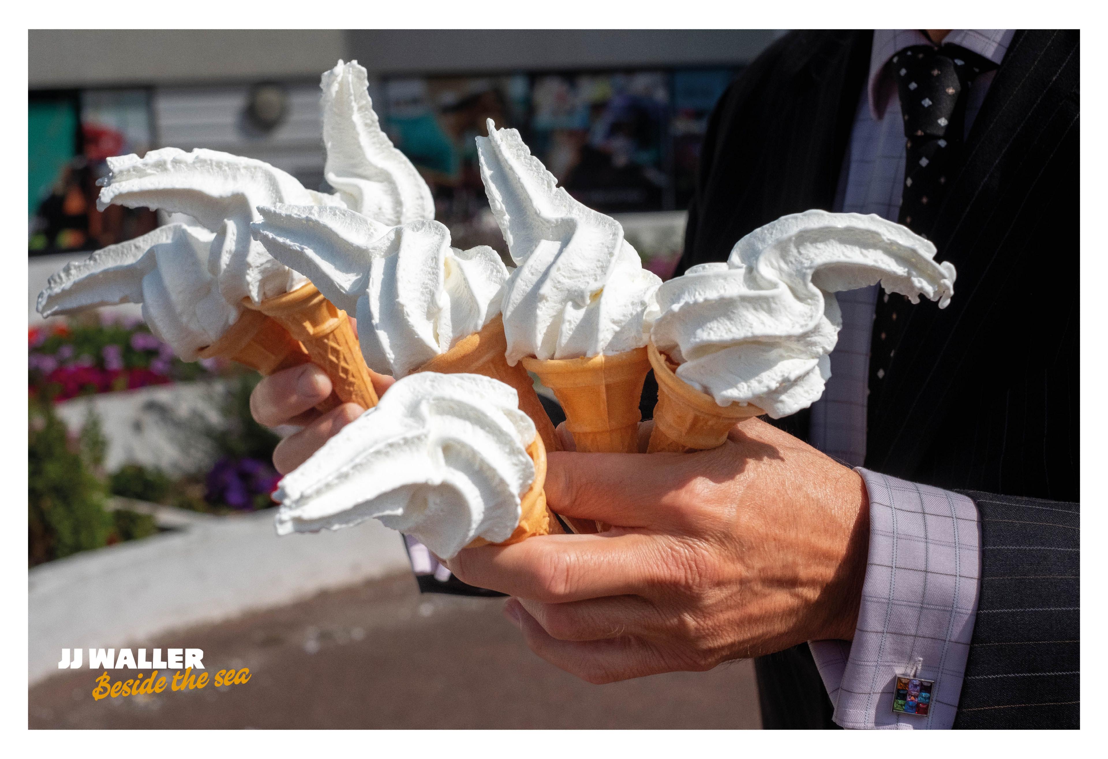 A man struggles to hold seven "99" style ice creams. 