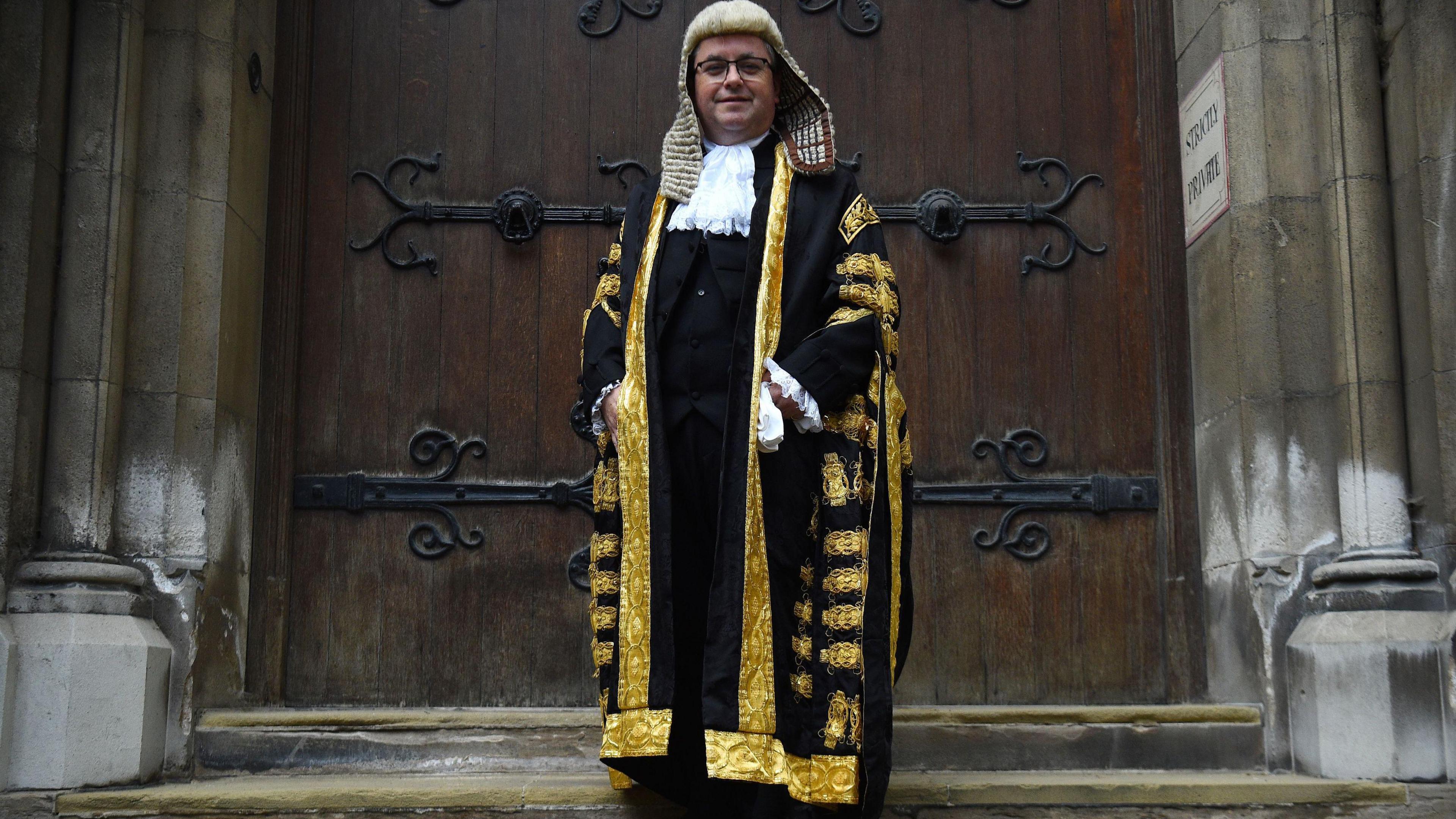 Robert Buckland QC arrives at the Royal Courts of Justice in London for his swearing in ceremony as Lord Chancellor wearing his ceremonial robes standing in front of large iron wrought wooden doors