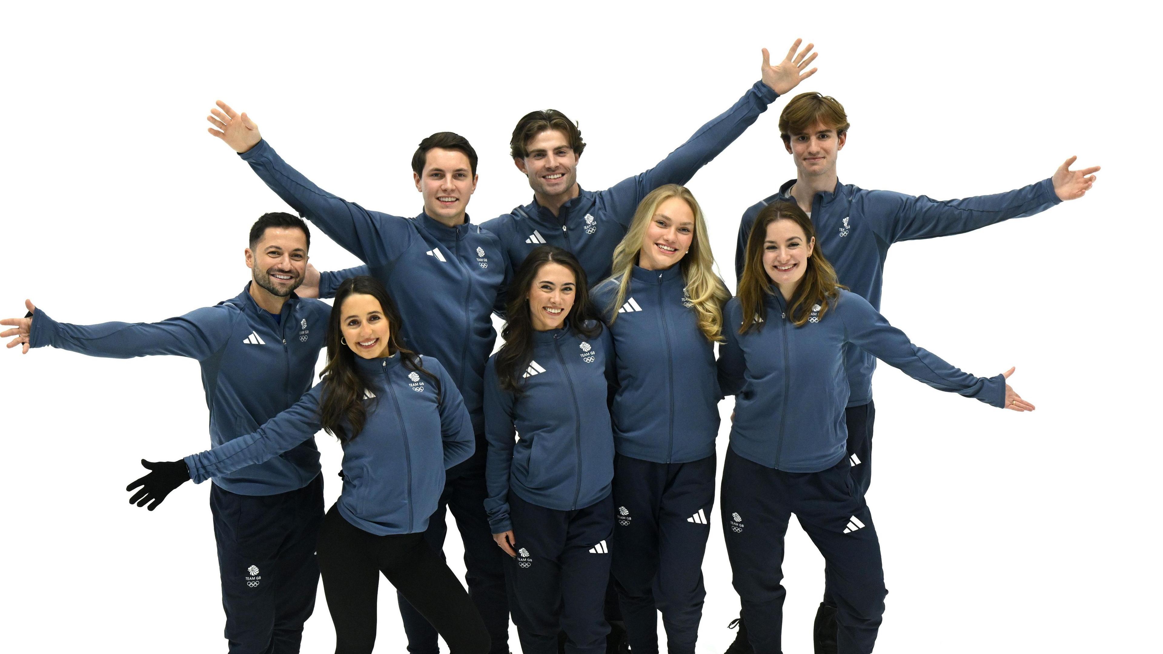 Great Britain skaters pose on the ice in a group photo, with six of the eight having an arm extended as they look cheerfully towards the camera.
Back row (L-R) Lewis Gibson, Luke Digby, James Hernandez, Edward Appleby. Front row (L-R) Lilah Fear, Ana Vaipan-Law, Phebe Bekker, Kristen Spours