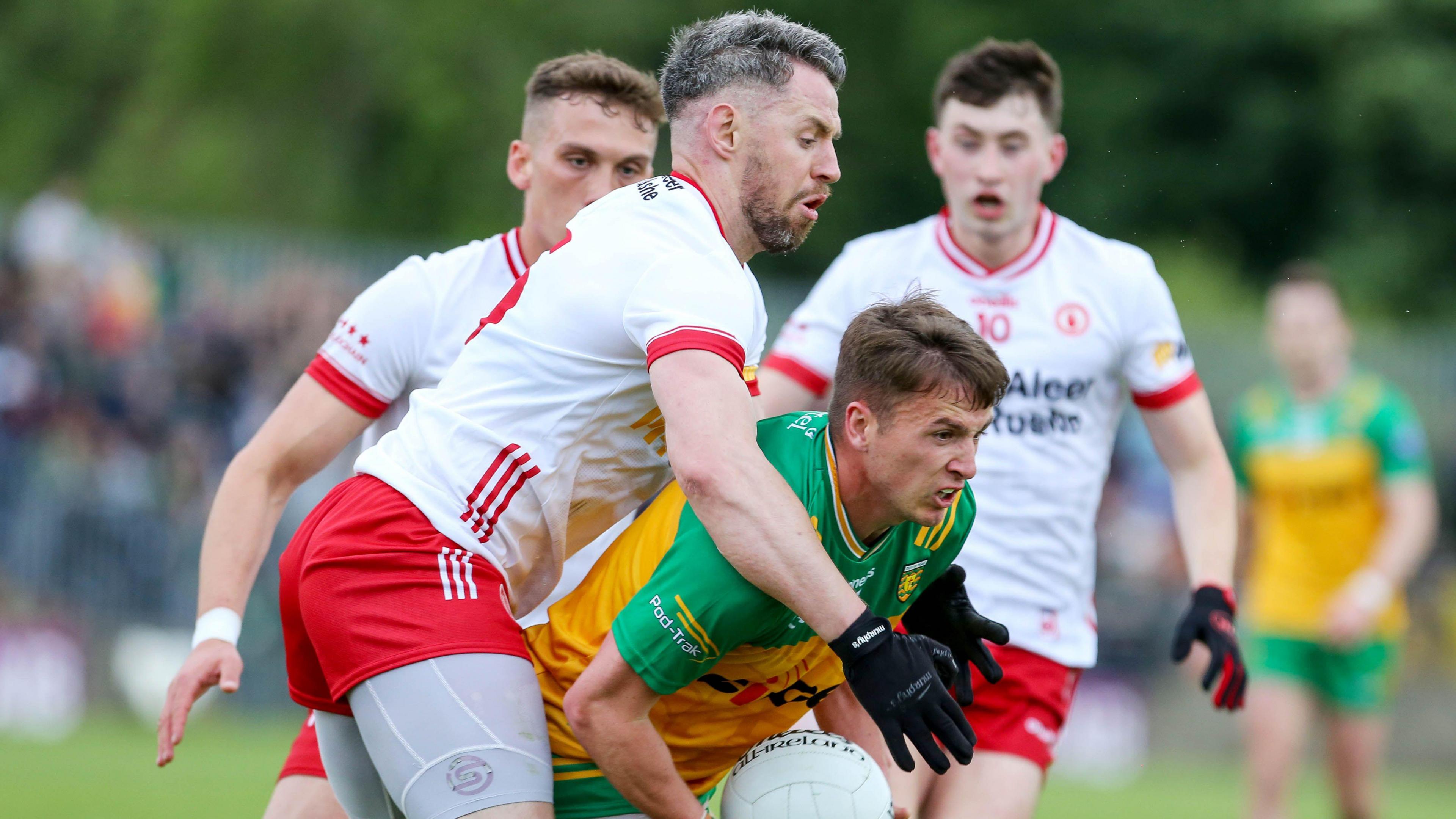 Peadar Morgan is tackled by Tyrone players