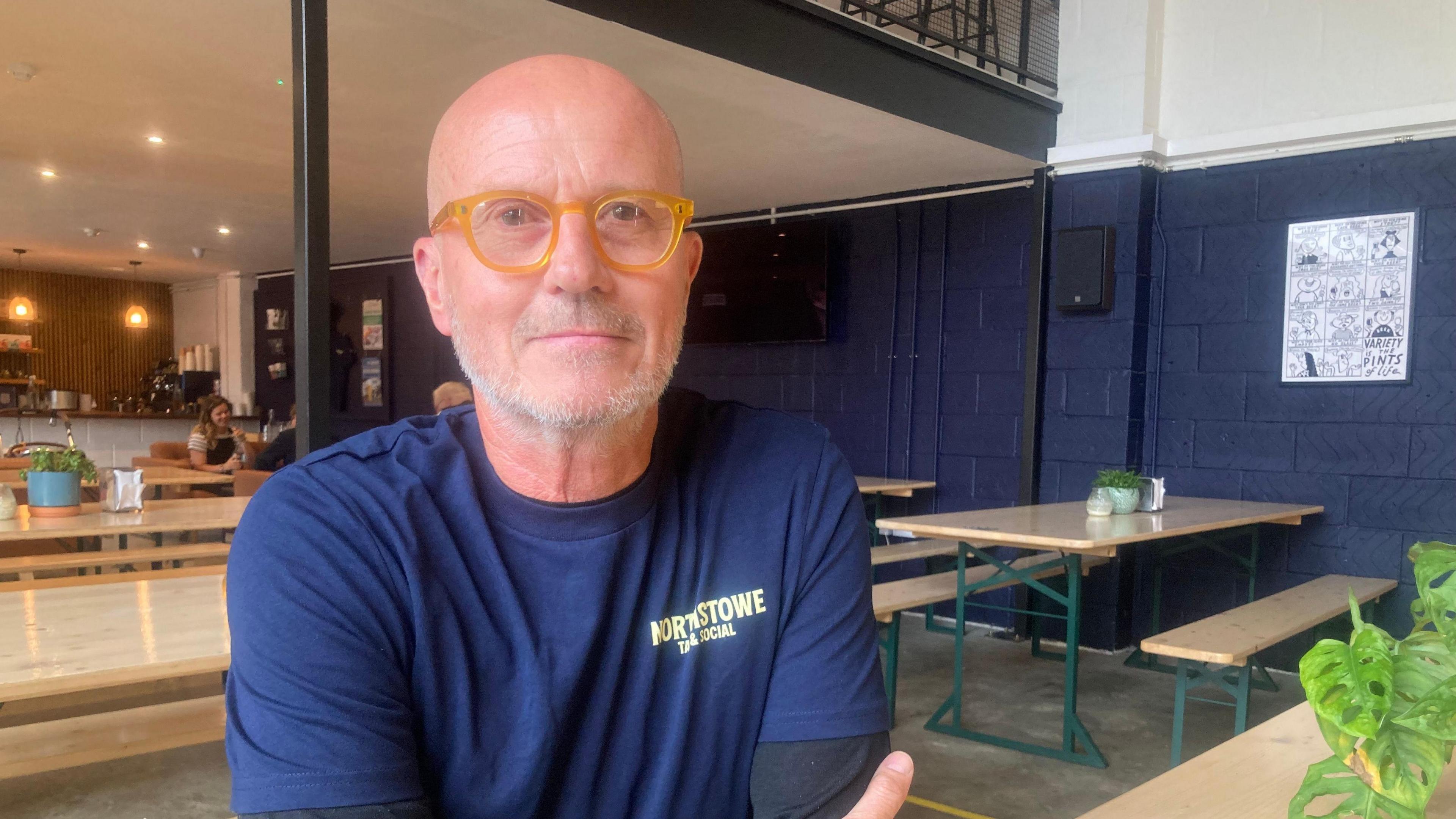 Stephen Brewer sitting at a bench in the Tap and Social 