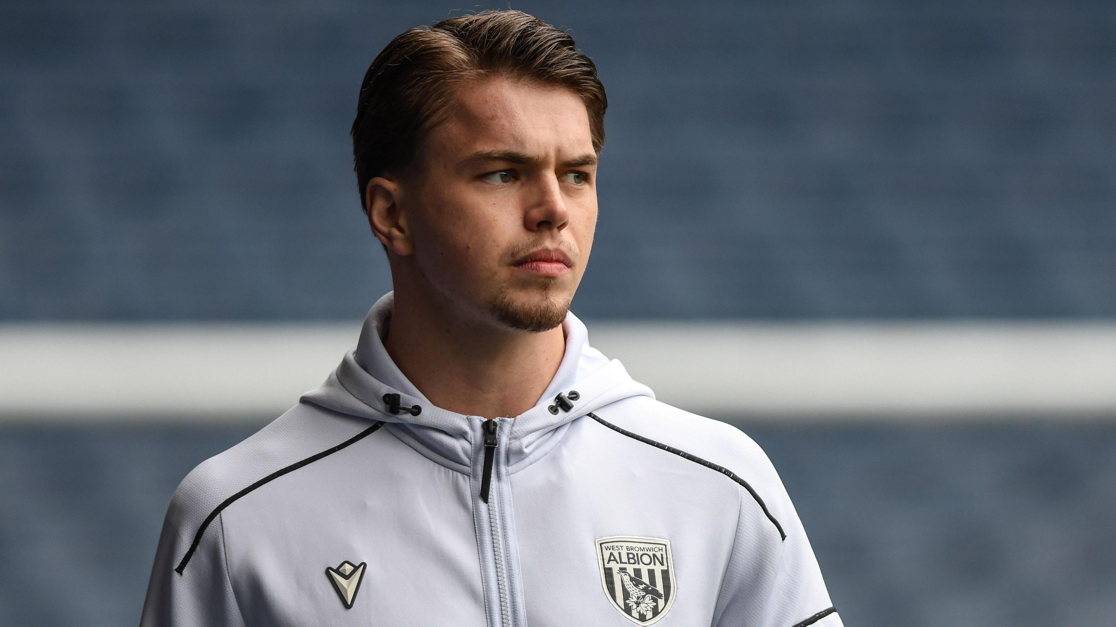 Josh Griffiths is wearing his West Bromwich Albion track top as he arrives for a game.