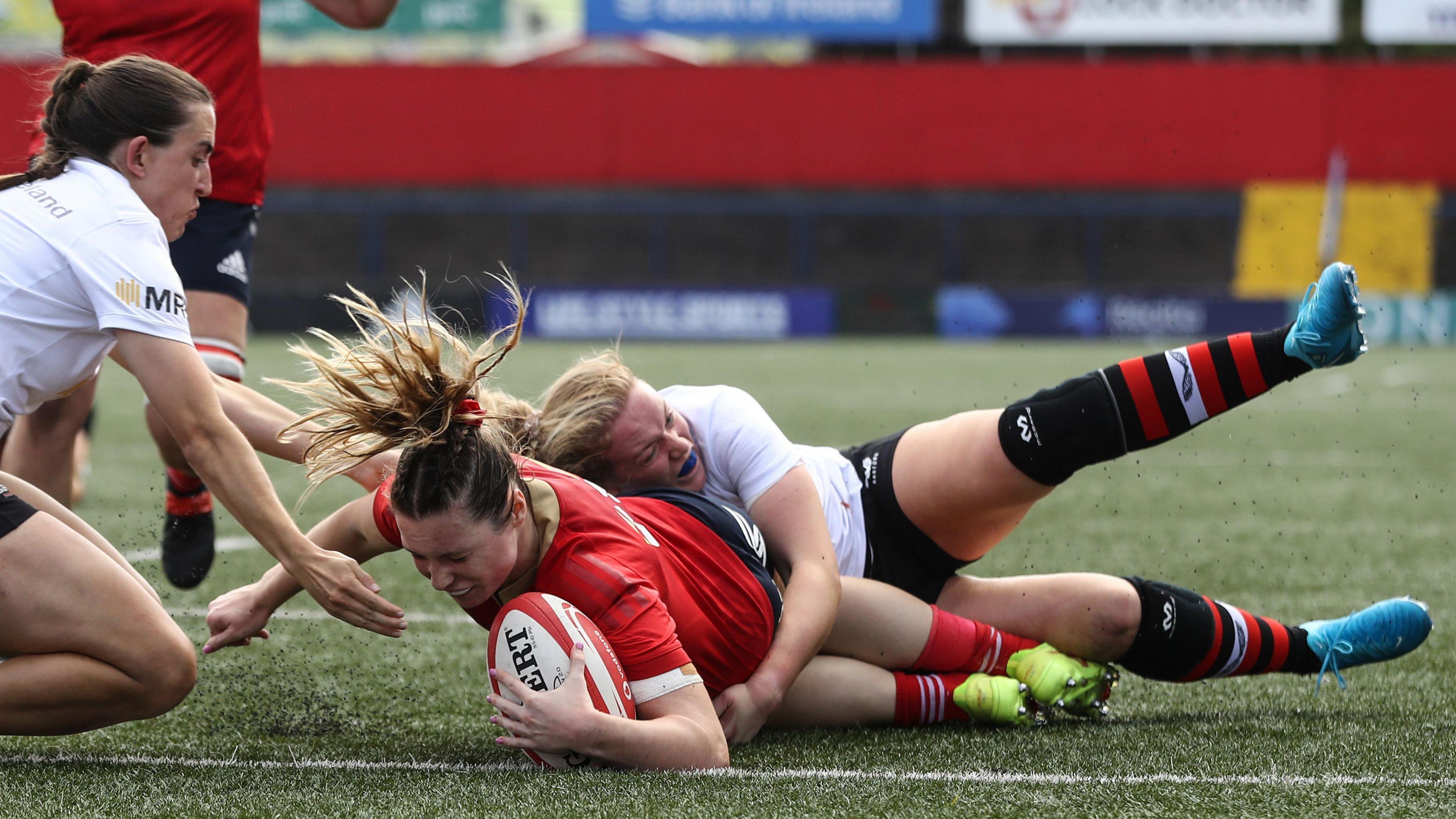 Alana McInerney scores his second try despite Vicky Irwin's best efforts