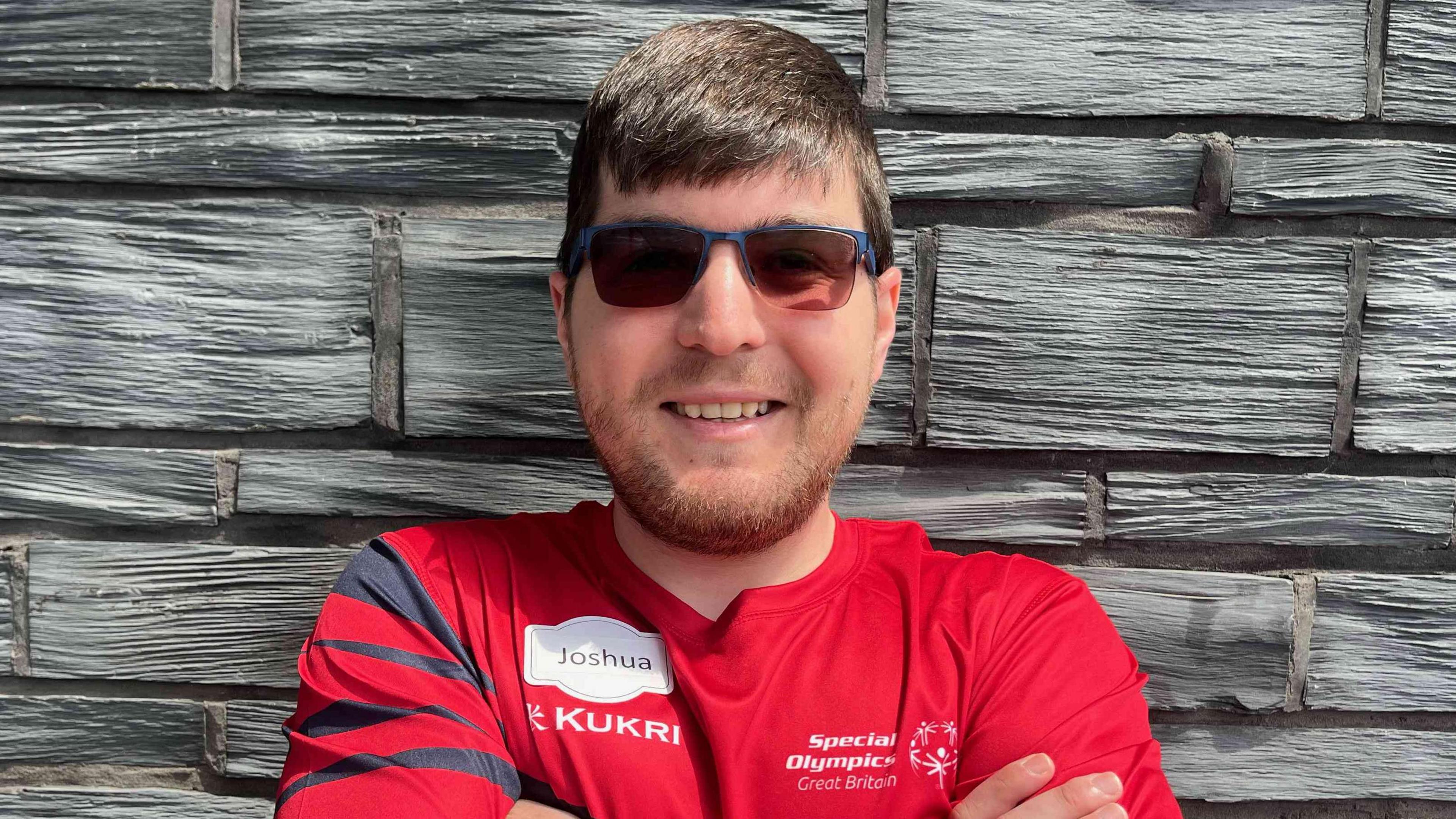 Joshua stood outside the Senedd with his arms crossed