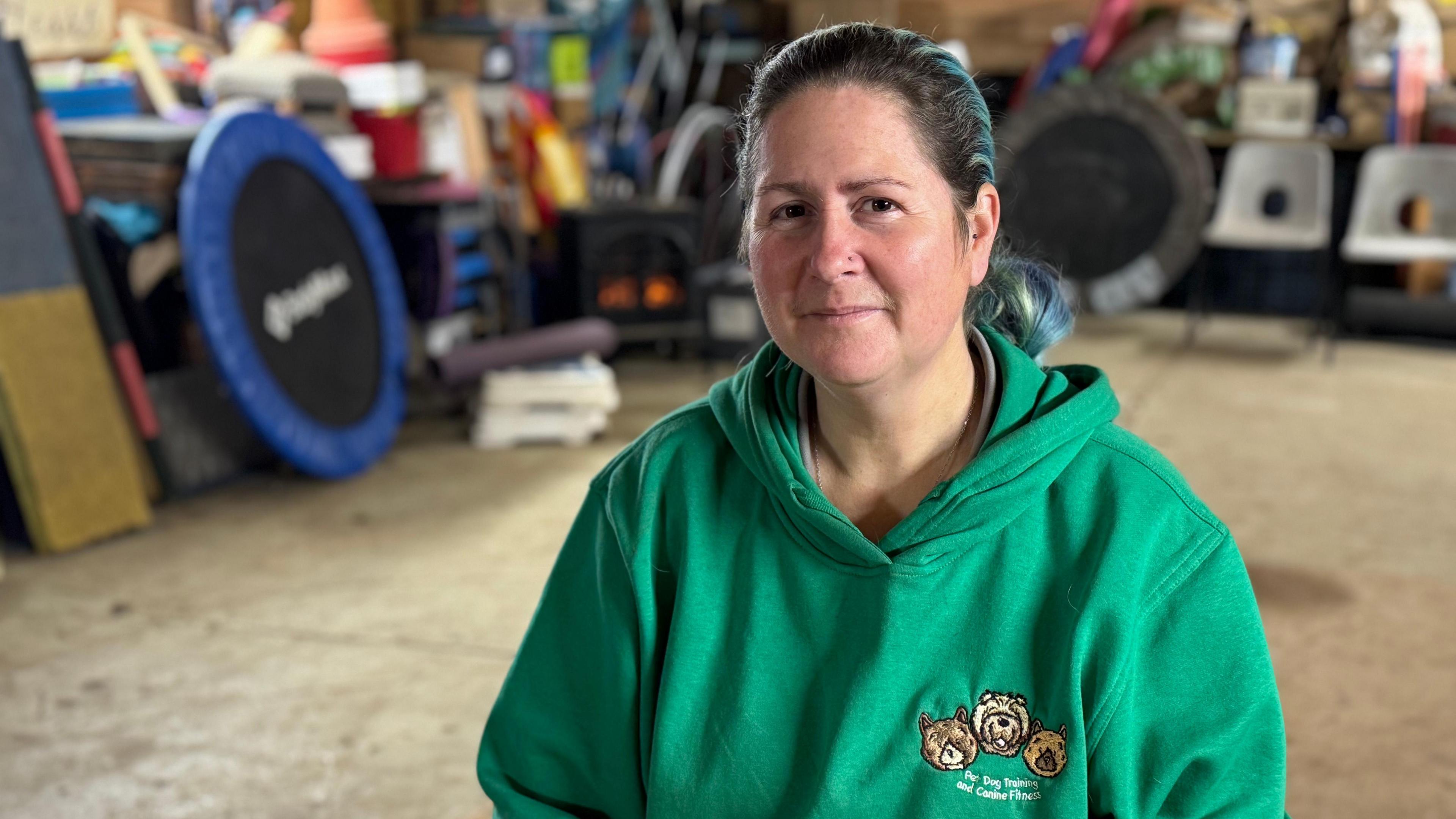 A woman wearing a grey hoodie looking into the camera smiling