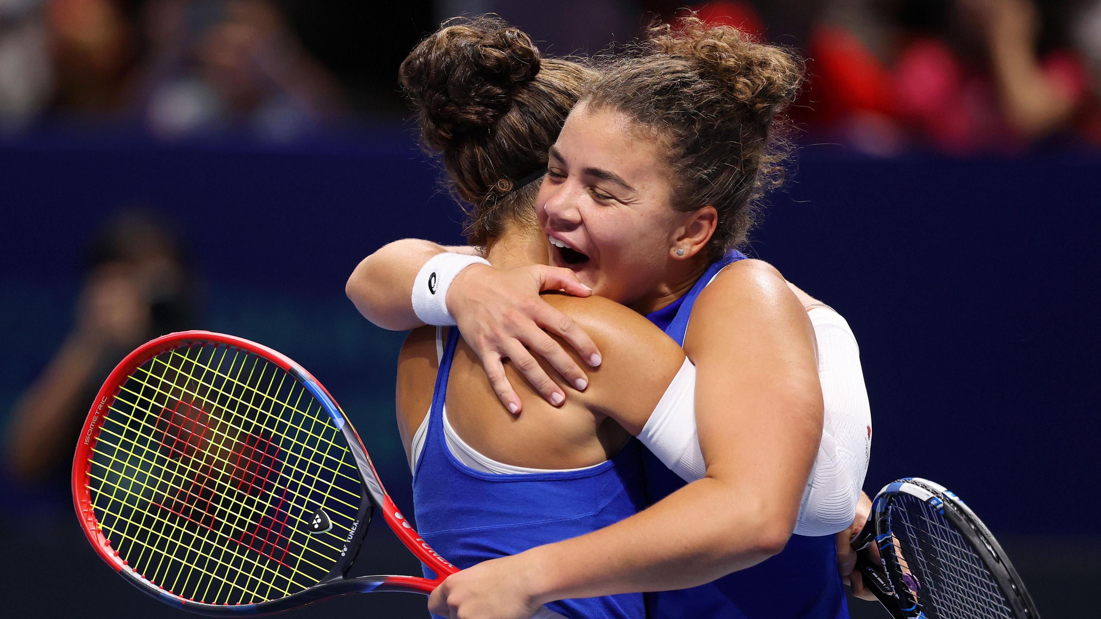 Jasmine Paolini and Sara Errani embrace after beating Ukraine in decisive Billie Jean King Cup doubles match