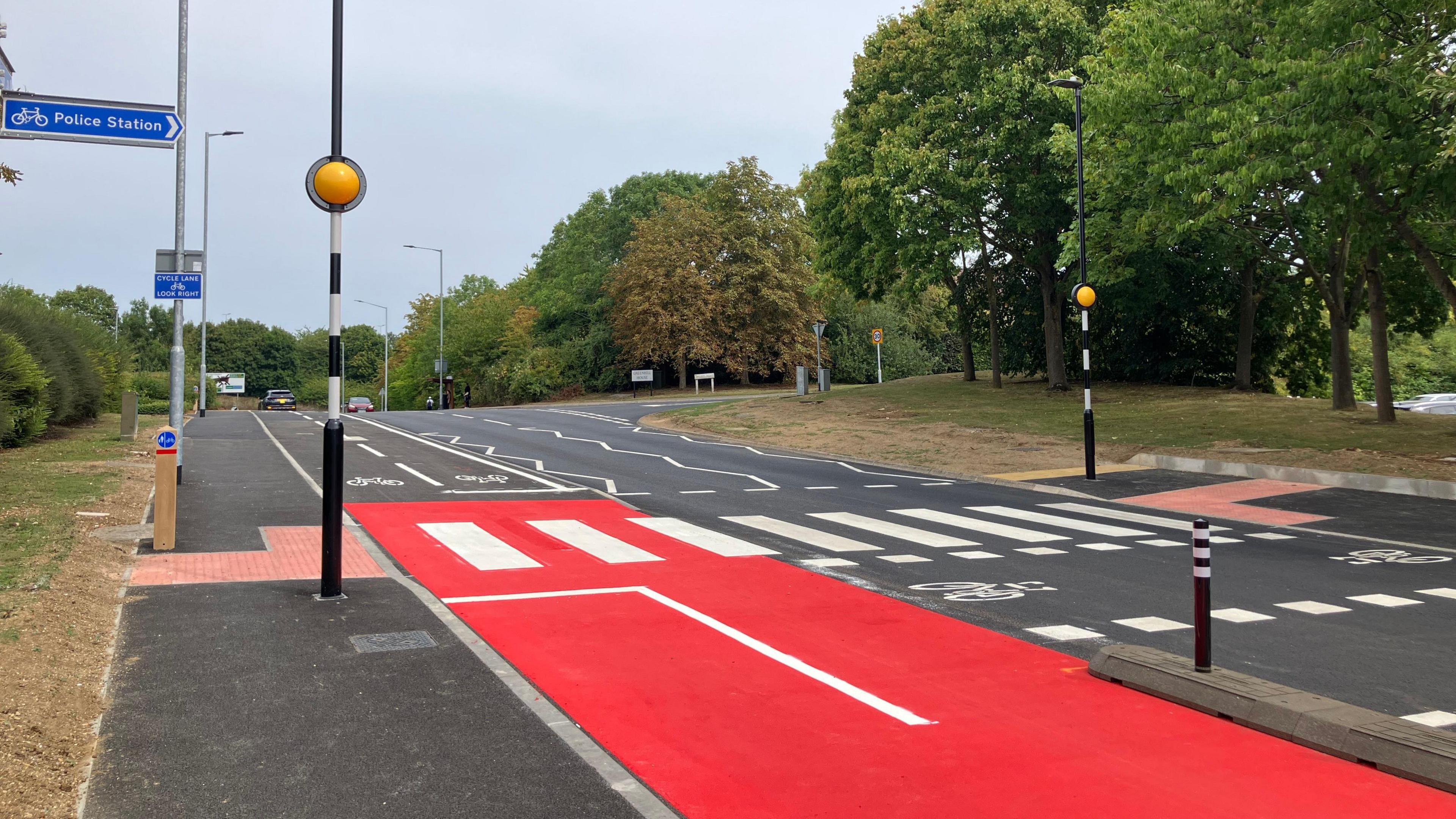 Thorpe Wood - with a red cycle path and a zebra crossing along the road 