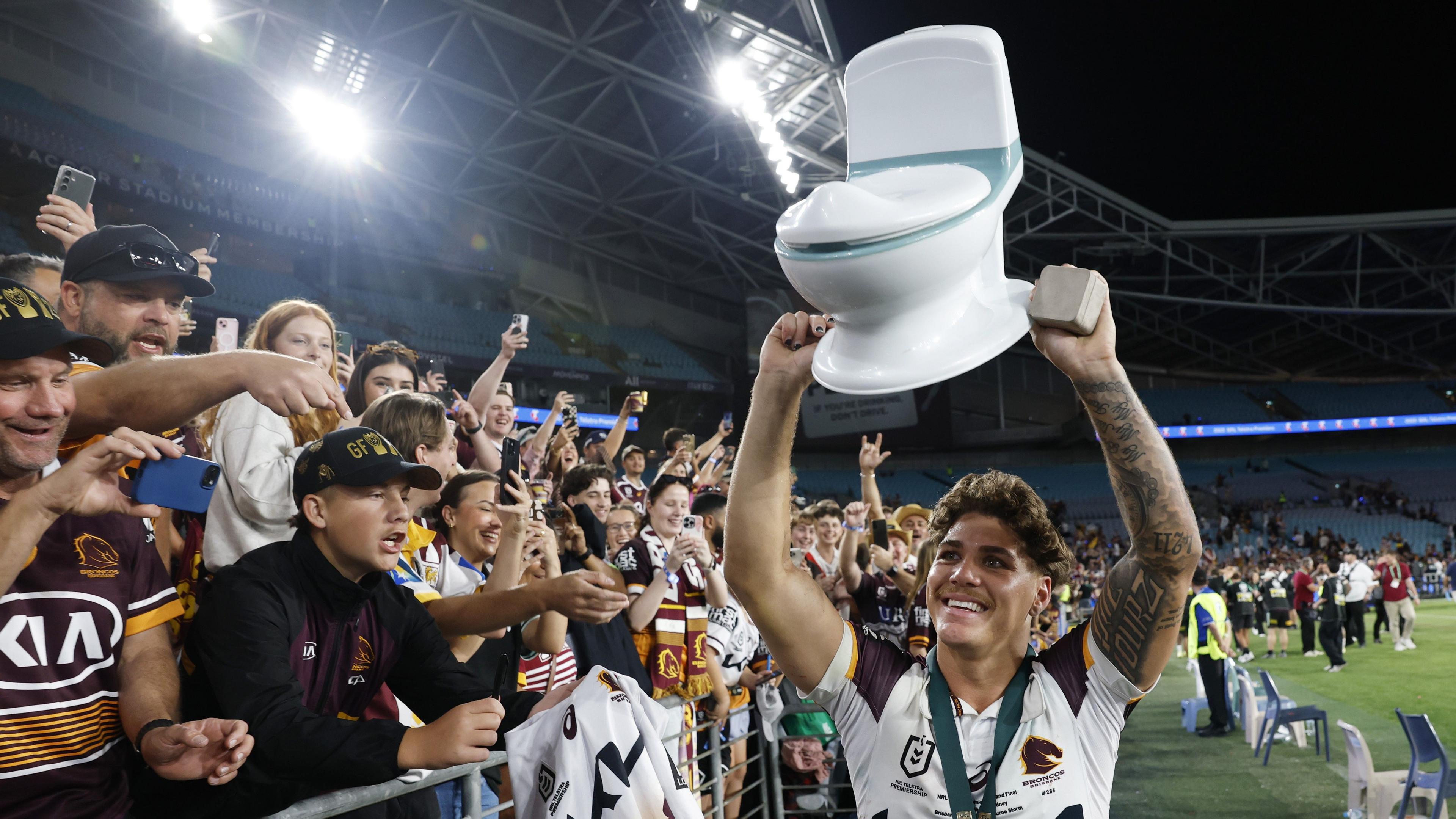 Reece Walsh holds aloft a miniature fake toilet