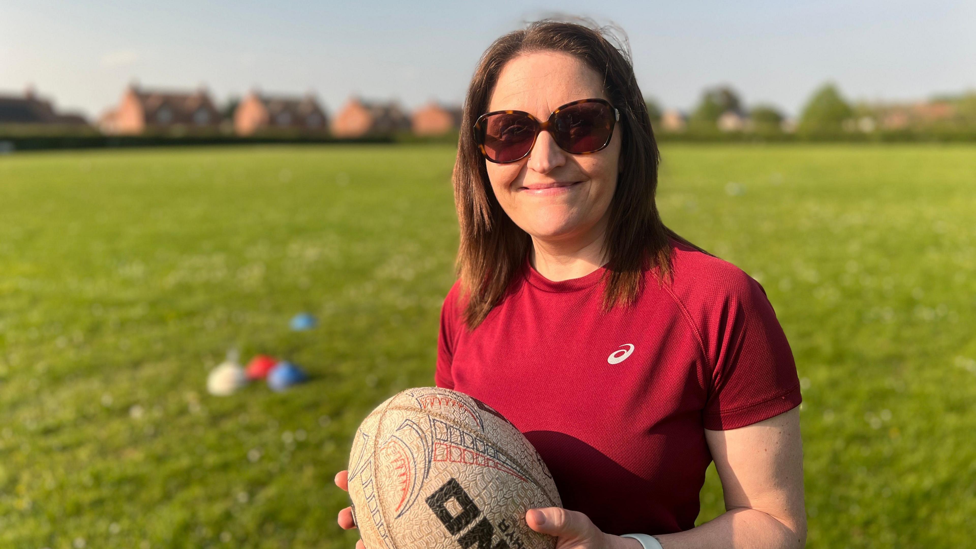 mother holding a rugby ball