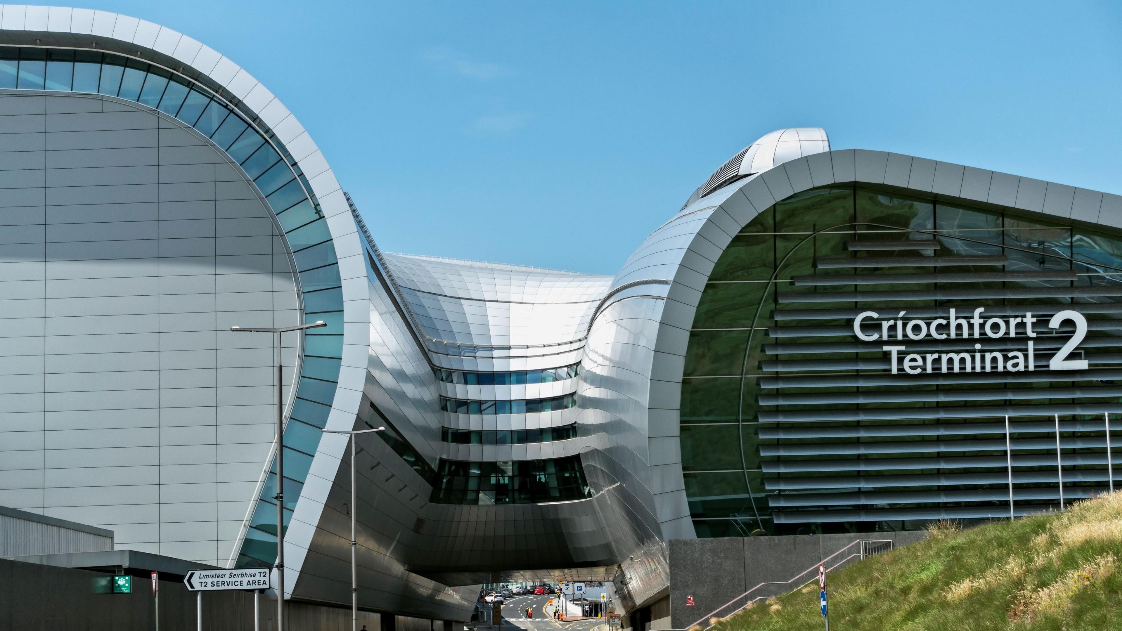 Dublin Airport on a sunny day. The terminal building is all glass and steel.