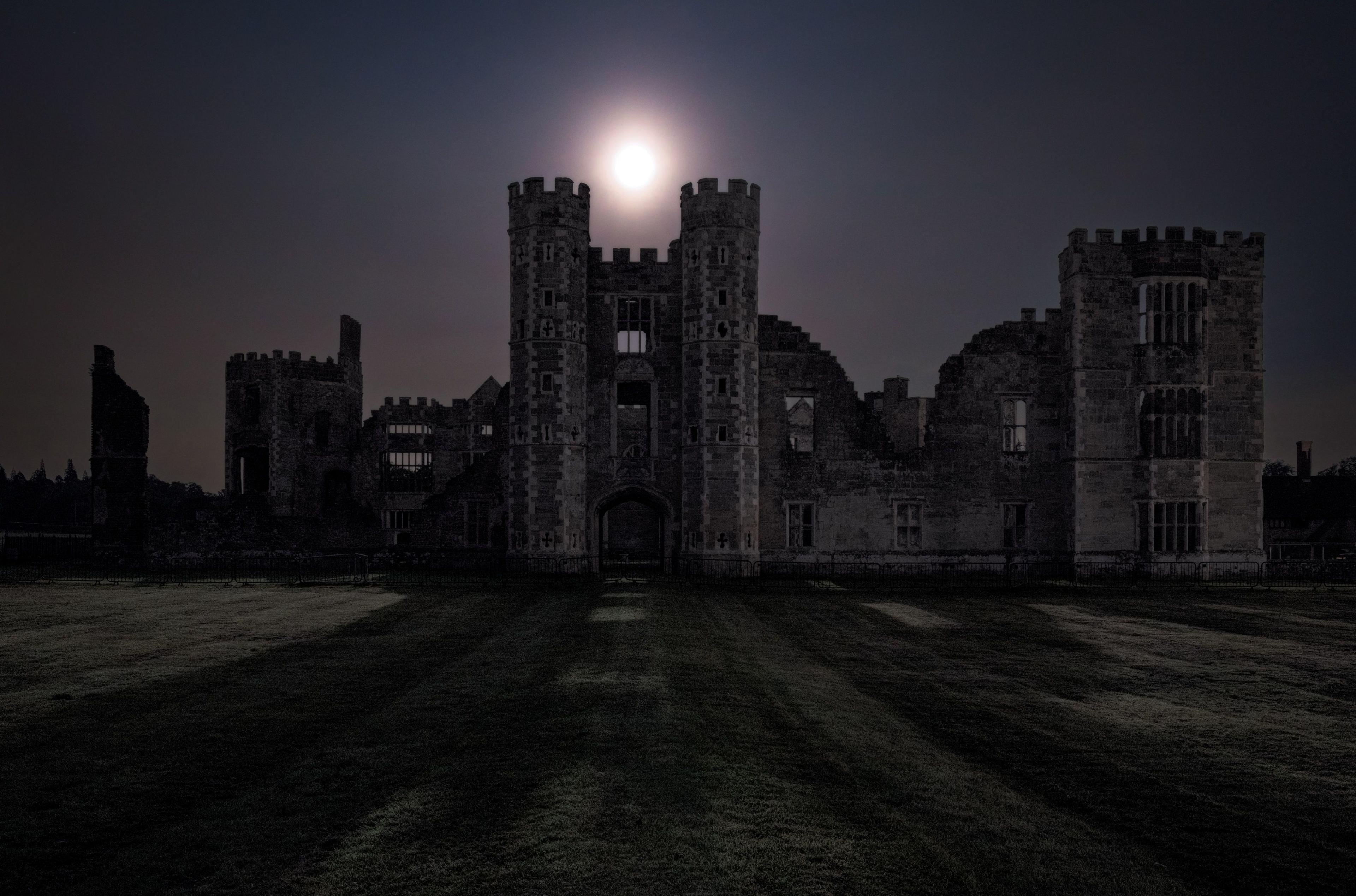 a full moon over a castle.