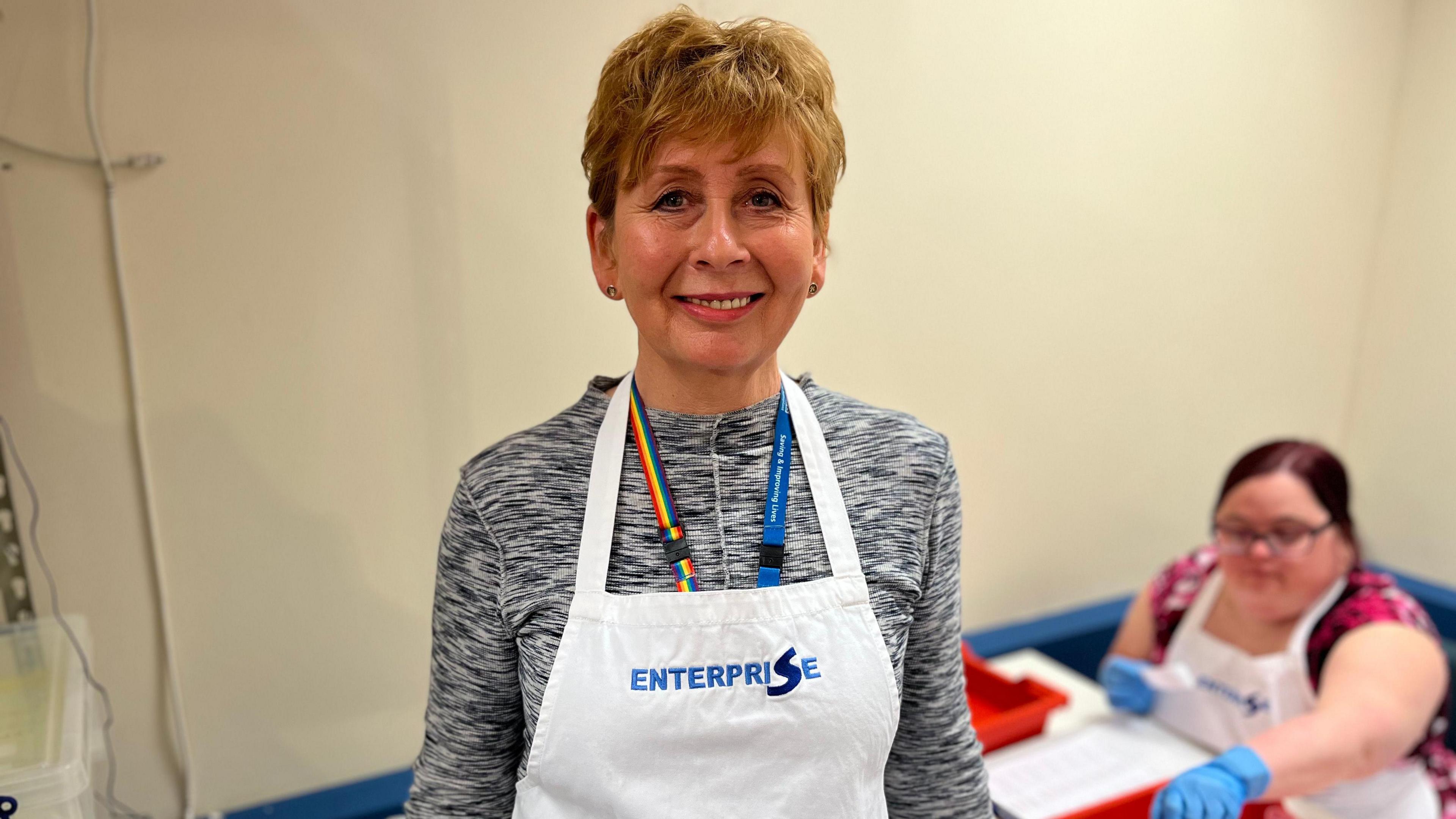 Cecilia McIntyre from NHS Blood & Transplant in a white apron, in front of a packaging station