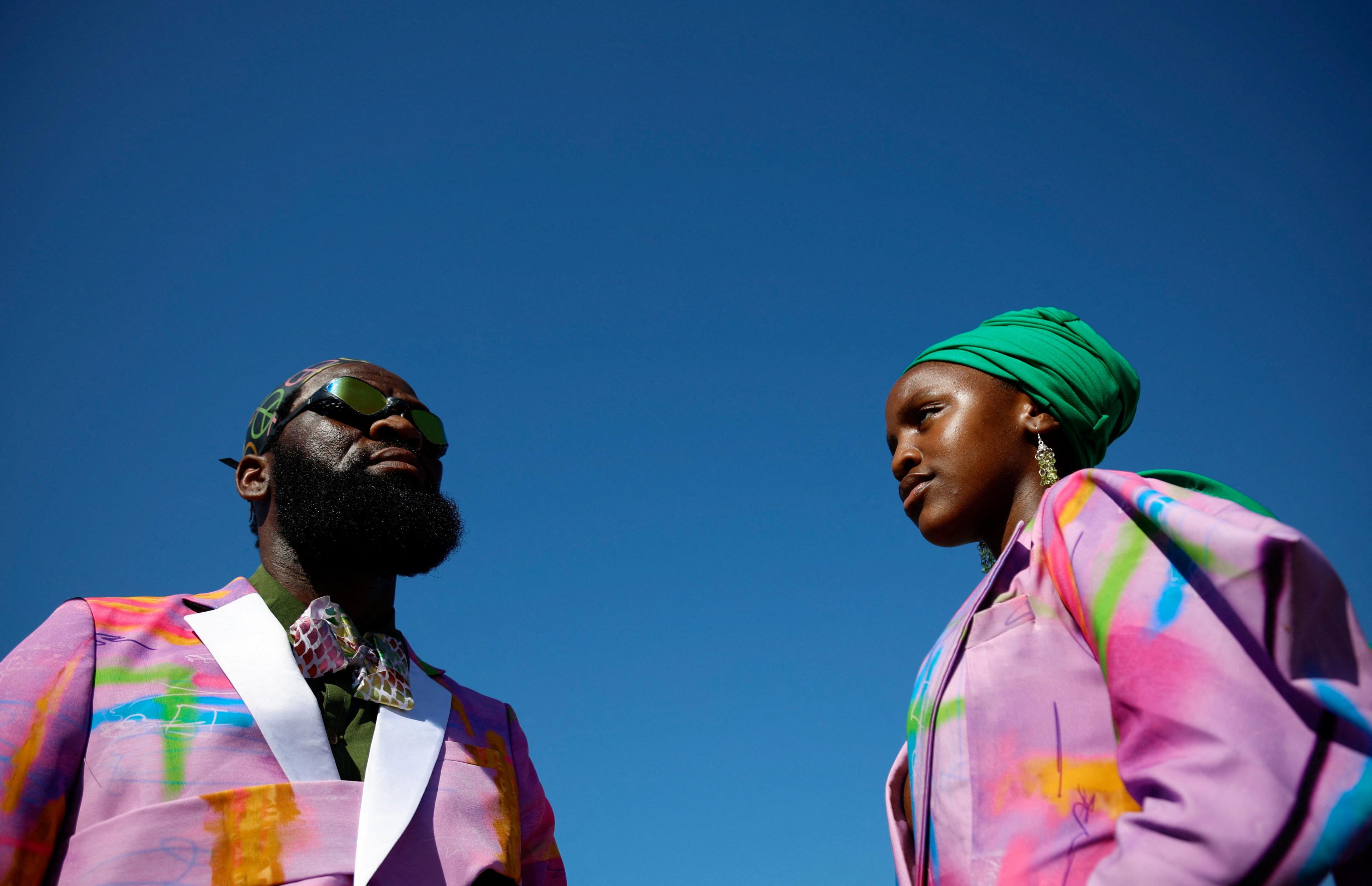 A man and a woman wear brightly dressed clothing.