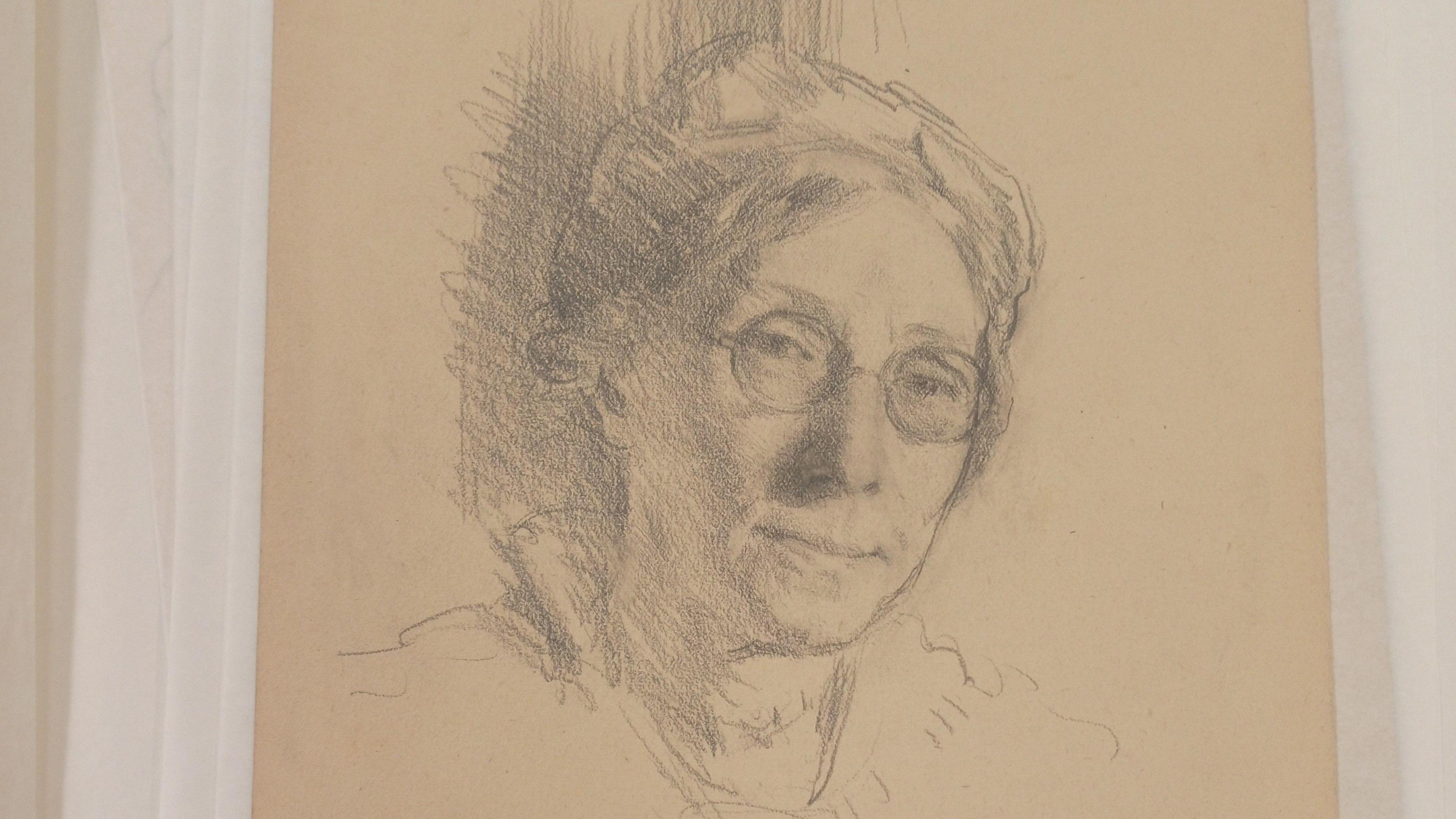 A pencil sketch of a woman with glasses.