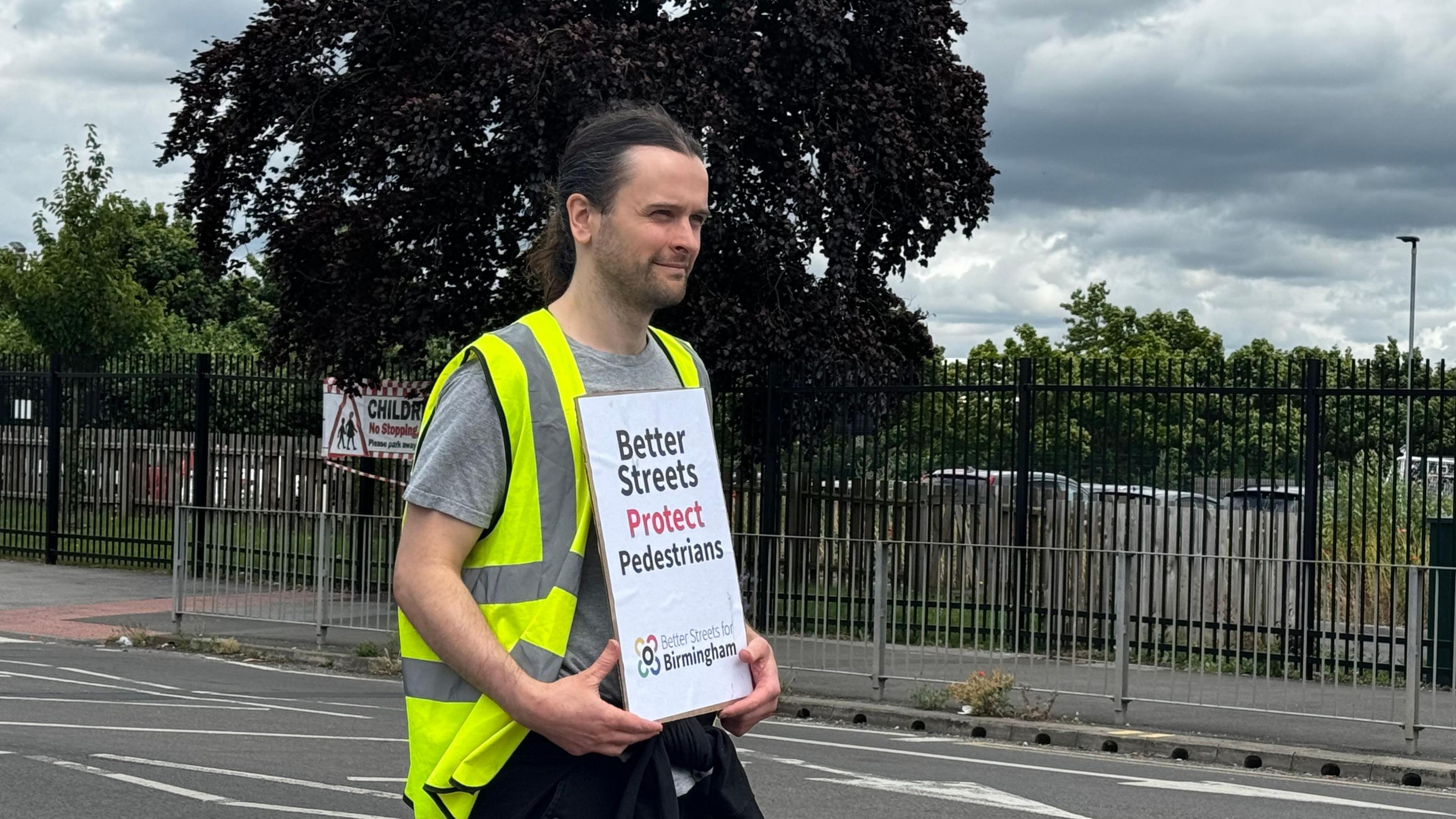 Matt MacDonald holds a road safety sign