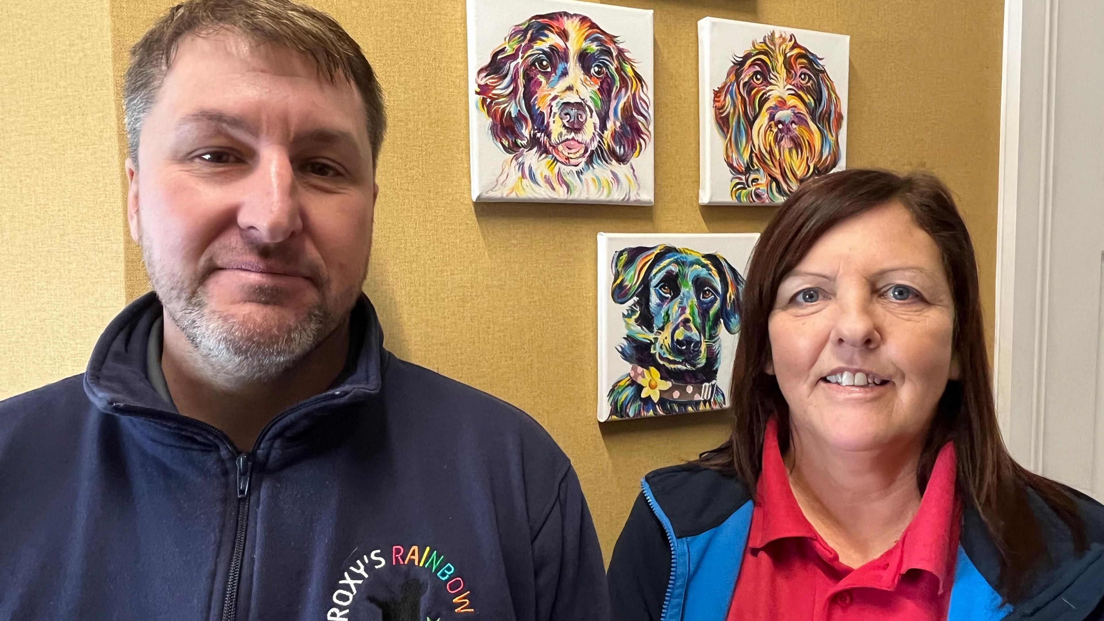 Darren Bates and Wendy Stone in front of dog portraits