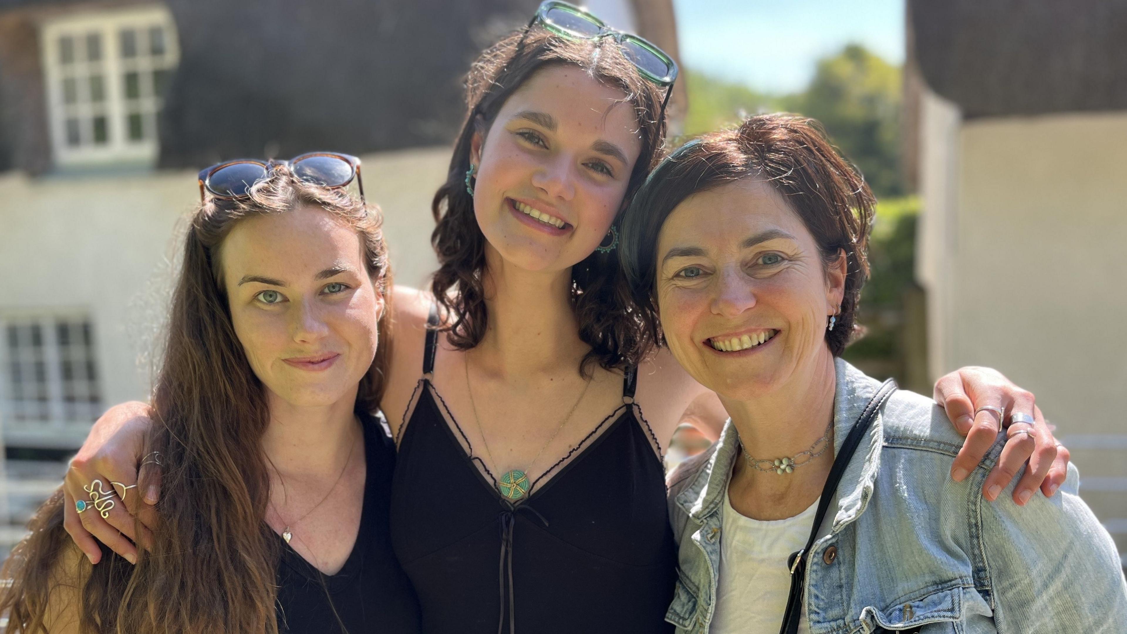 Harmony Jagla standing in the centre of Tess Buckley and Ruth Corfield with her arms around them, all three smiling