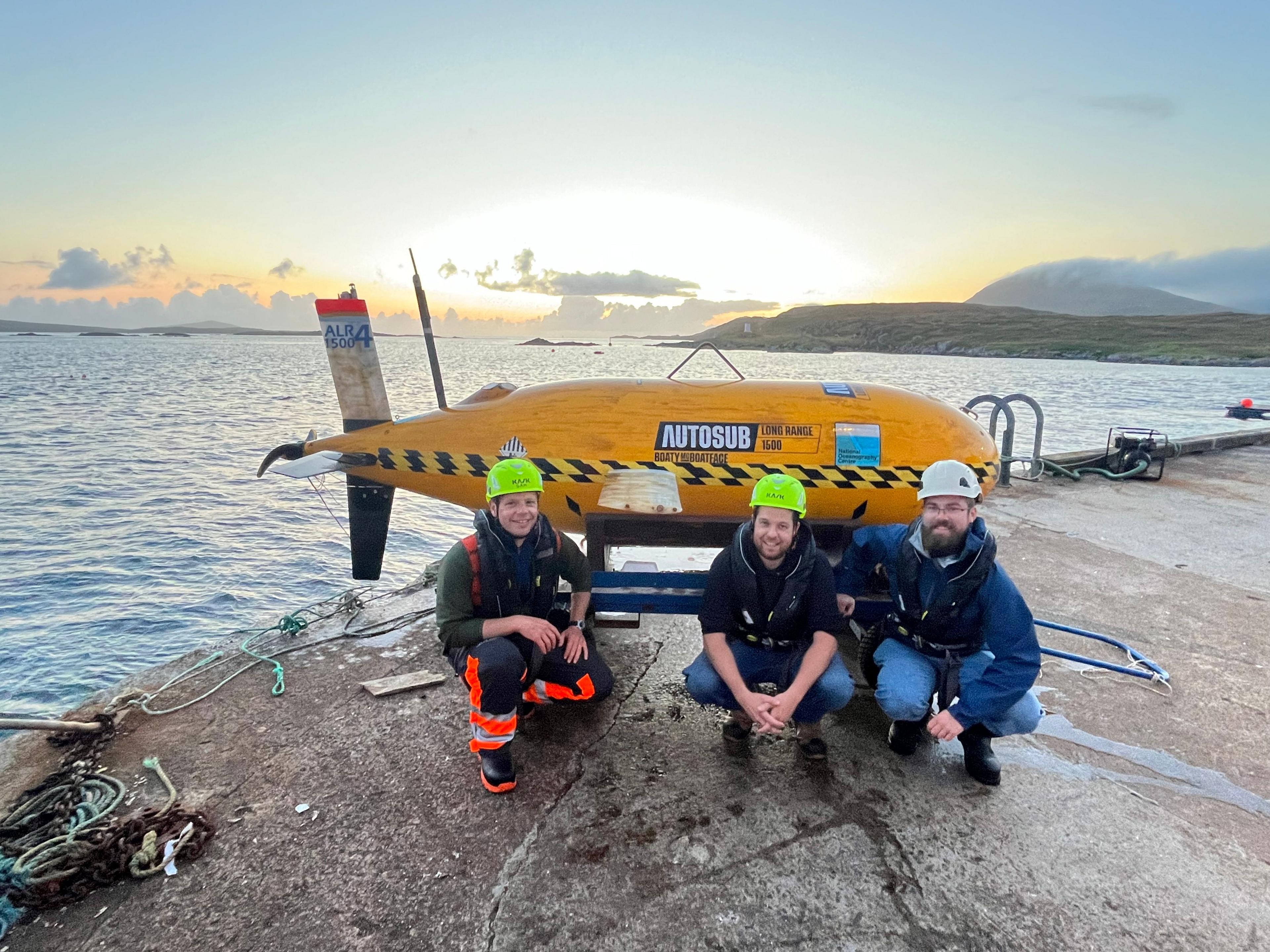 Boaty McBoatface with three engineers on a quayside on Isle of Harris