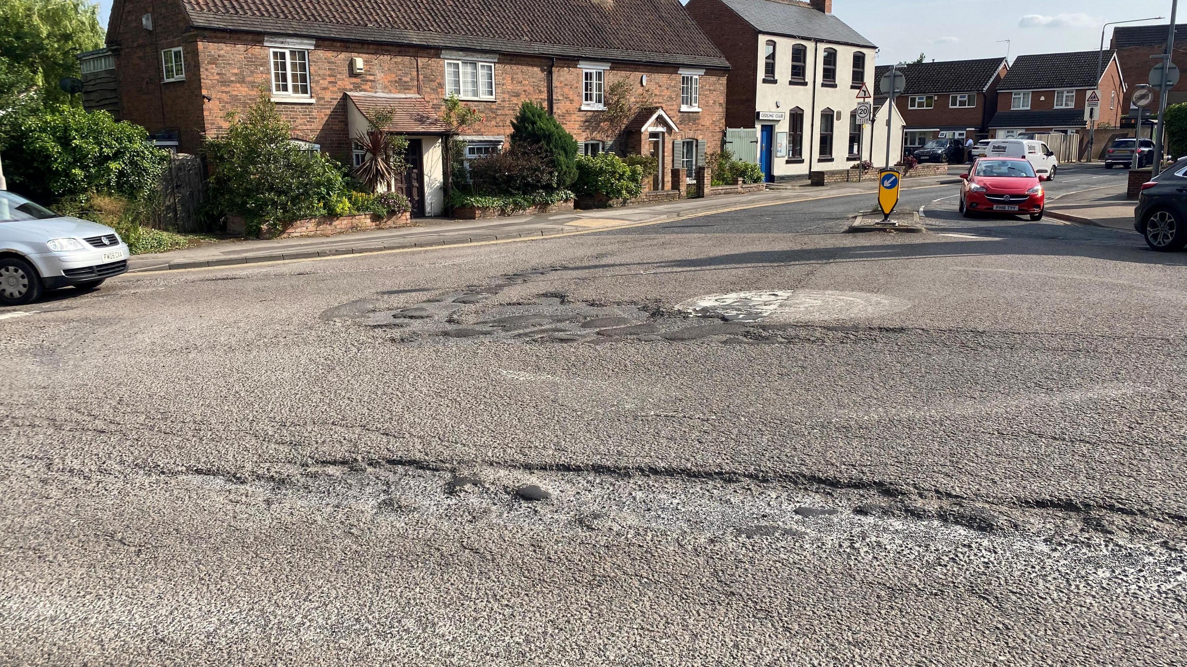An image of potholes around a mini roundabout.