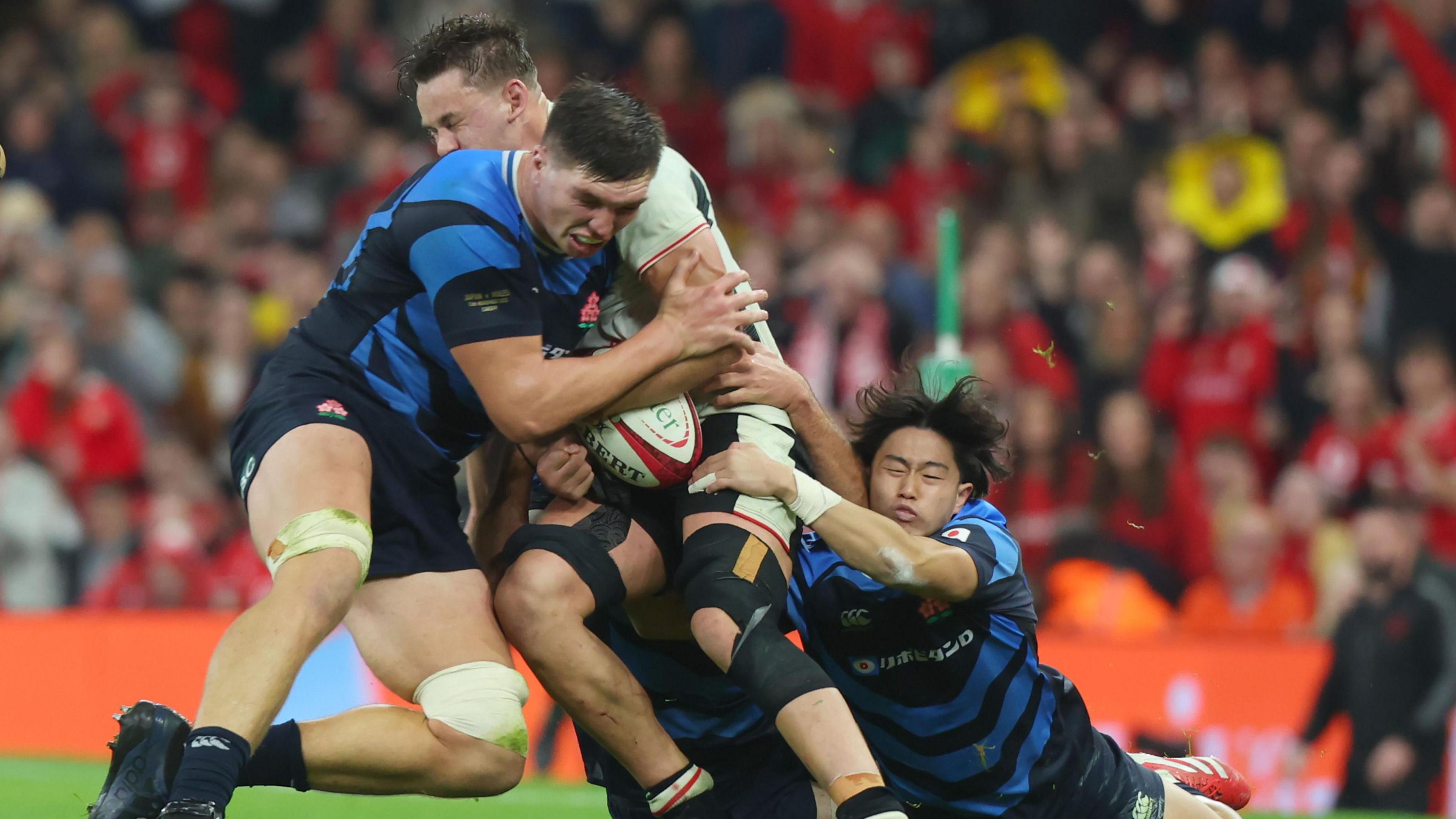 Japan's Harry Hockings tackles Wales' Alex Mann late in their autumn international match in Cardiff