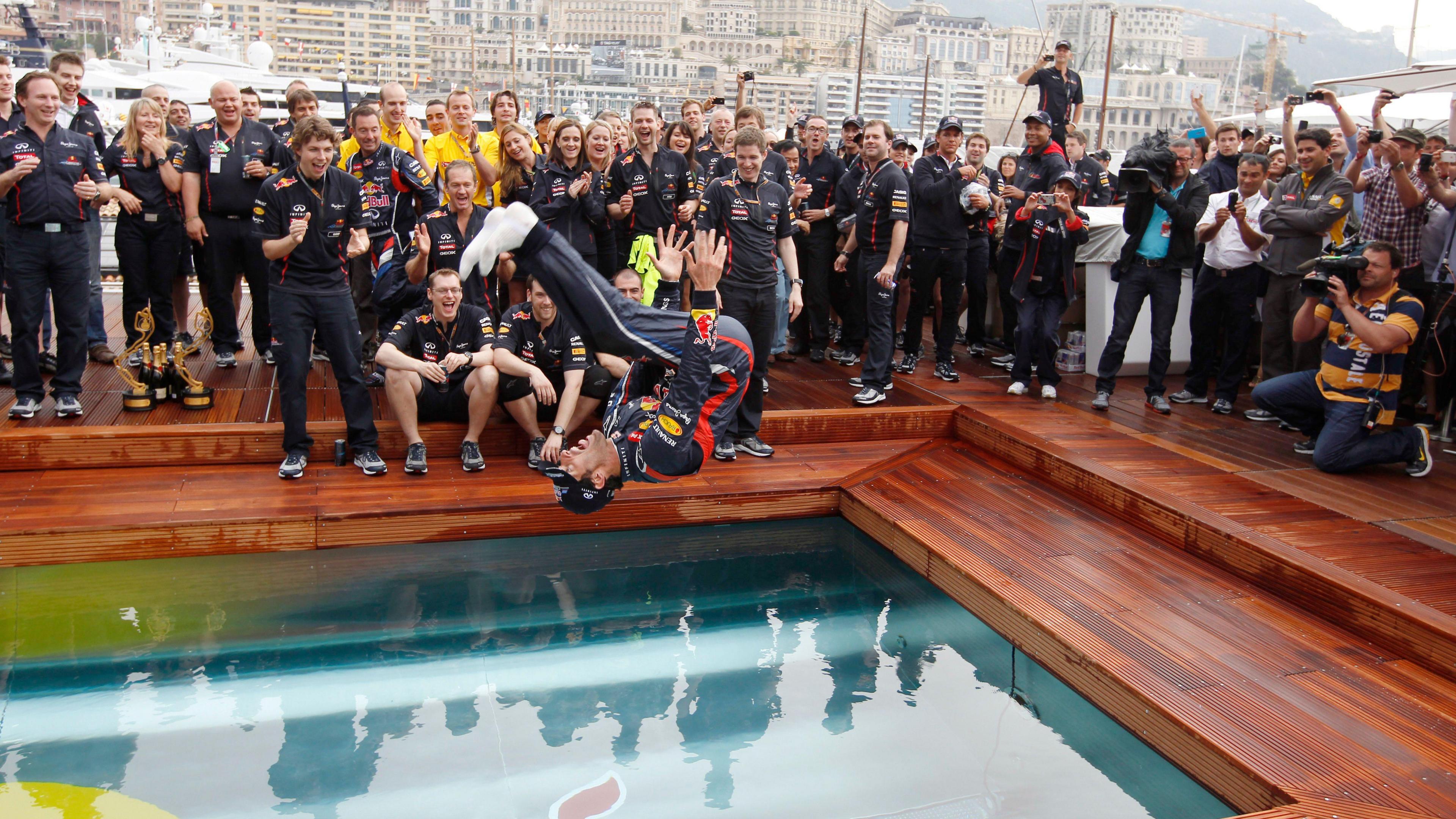 Race winner Mark Webber somersaults into a swimming pool as he celebrates in 2012 with his Red Bull team