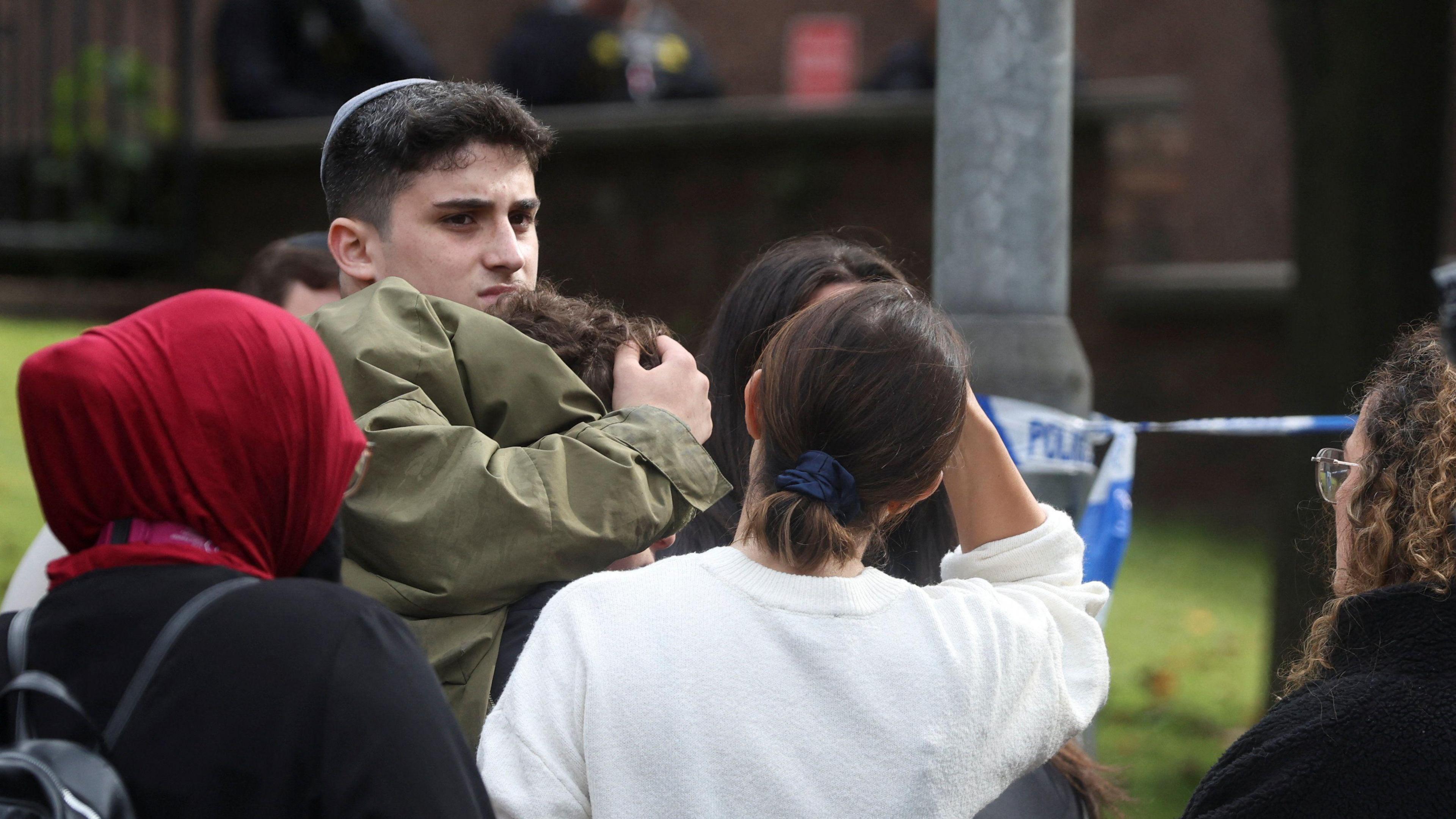 People gather near the scene following an incident outside a synagogue, in Manchester. 